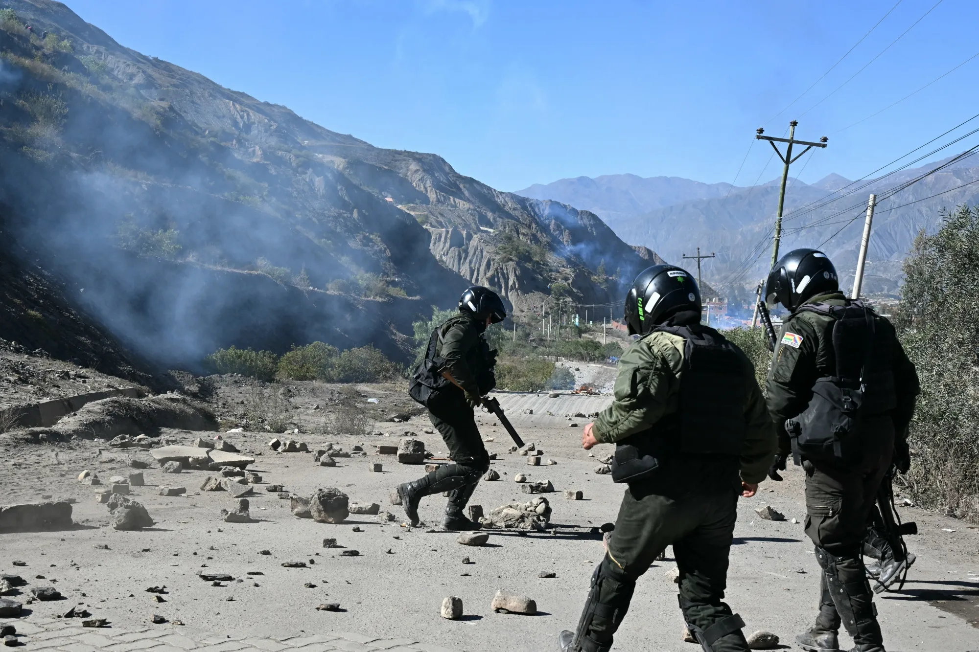 Riot police officers remove rocks from a road blocked by rural protesters in Lipari, La Paz department, Bolivia, on May 16.