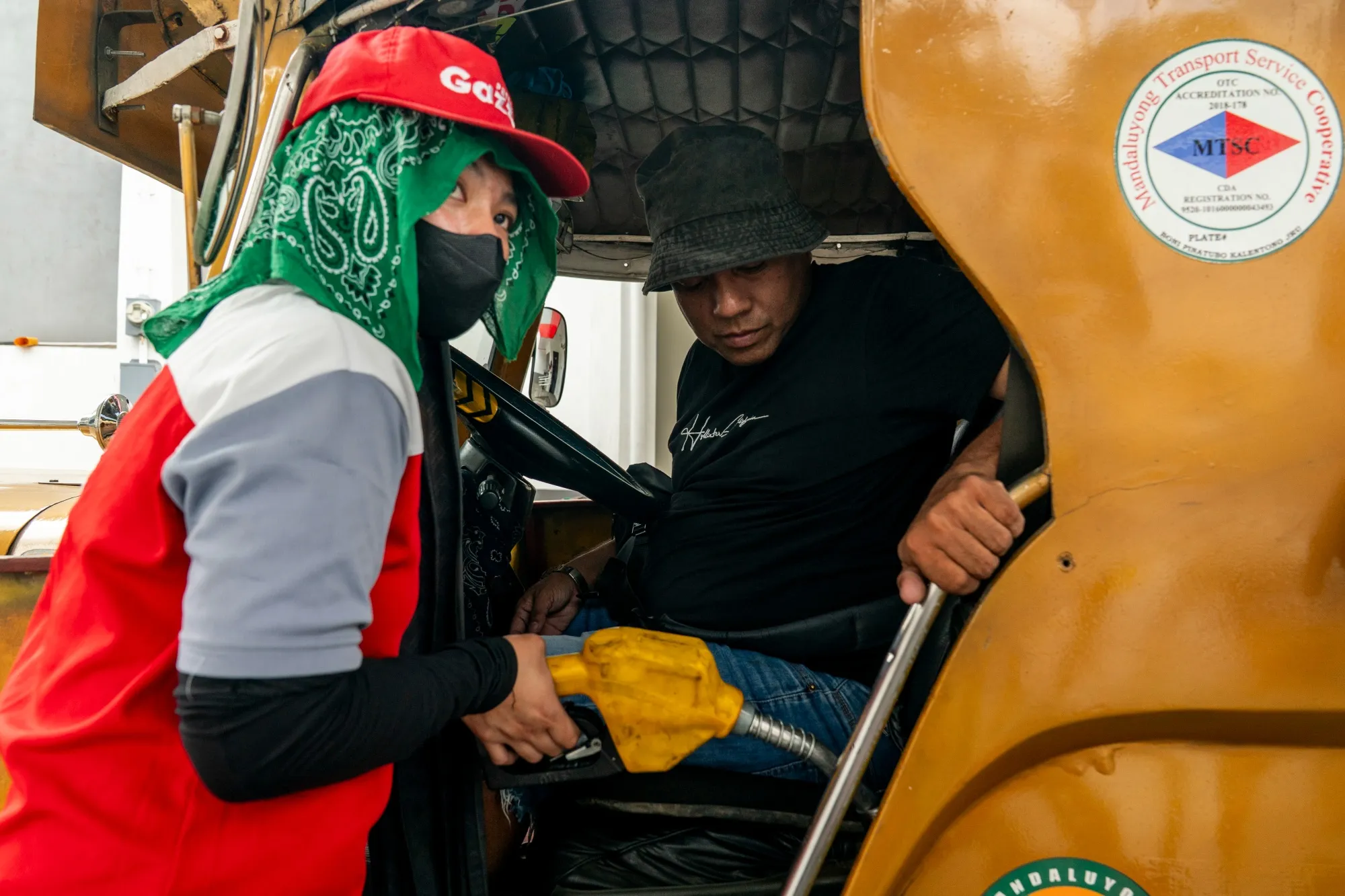 A worker refuels a jeepney at a gas station in Mandaluyong, the Philippines.