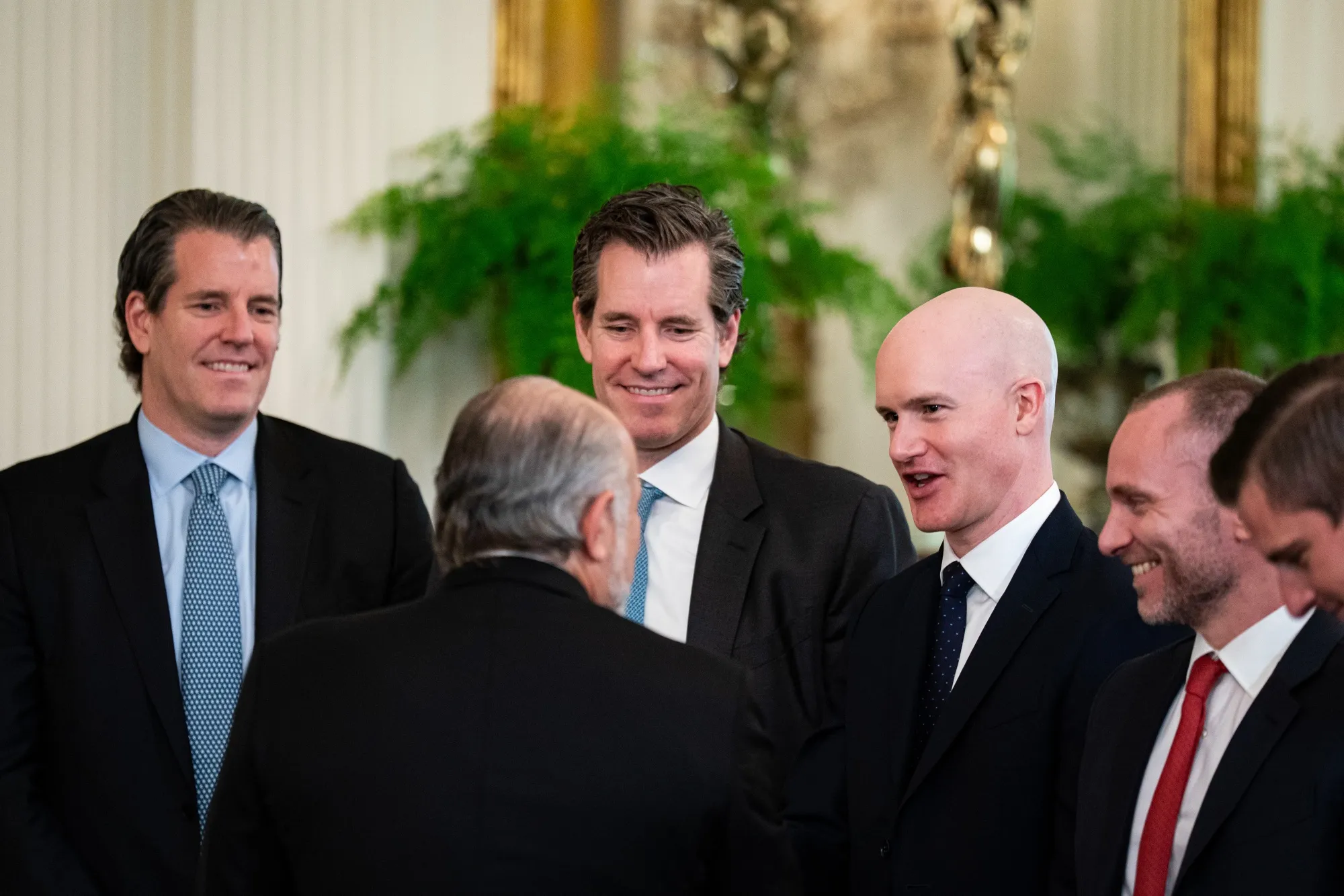 Tyler and Cameron Winklevoss, Brian Armstrong and Paolo Ardoino speak with Commerce Secretary Lutnick at a signing ceremony for GENIUS Act at the White House in July 2025