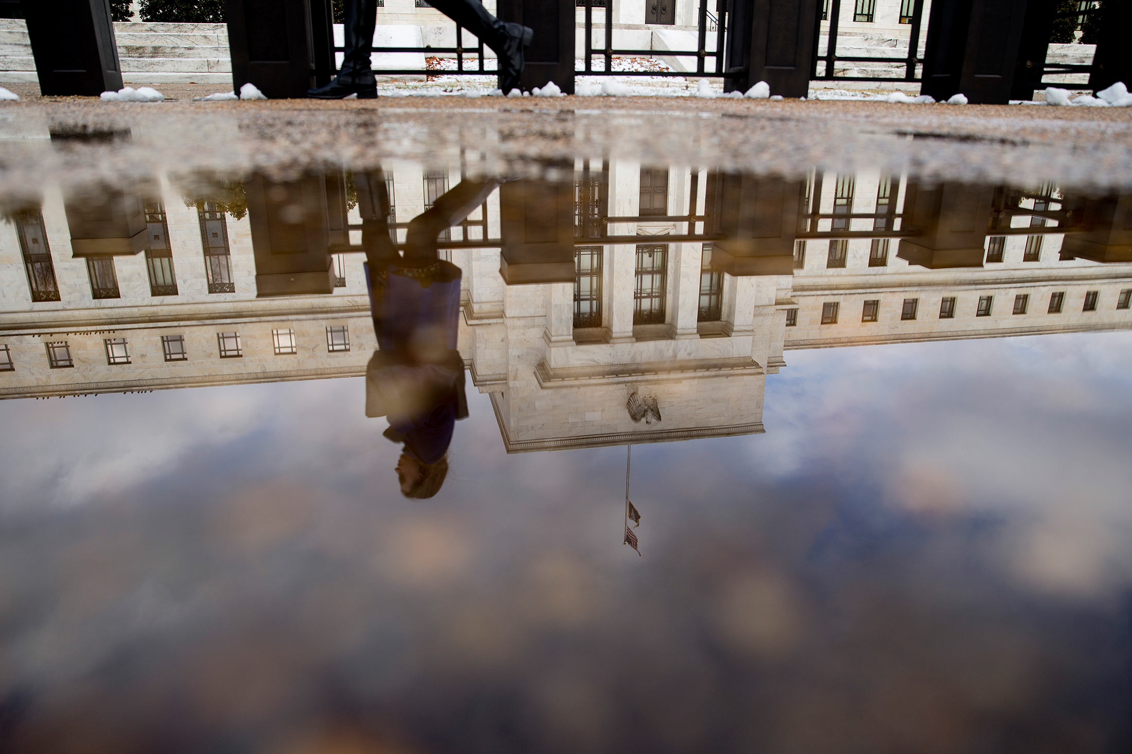 A woman walks past the Marriner S. Eccles Federal Reserve building in Washington D.C.
