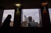 A pedestrian passes skyscrapers in the City of London.