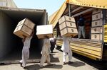 Iranian workers transfer goods from a cargo container to trucks at the Kalantari port in city of Chabahar.
