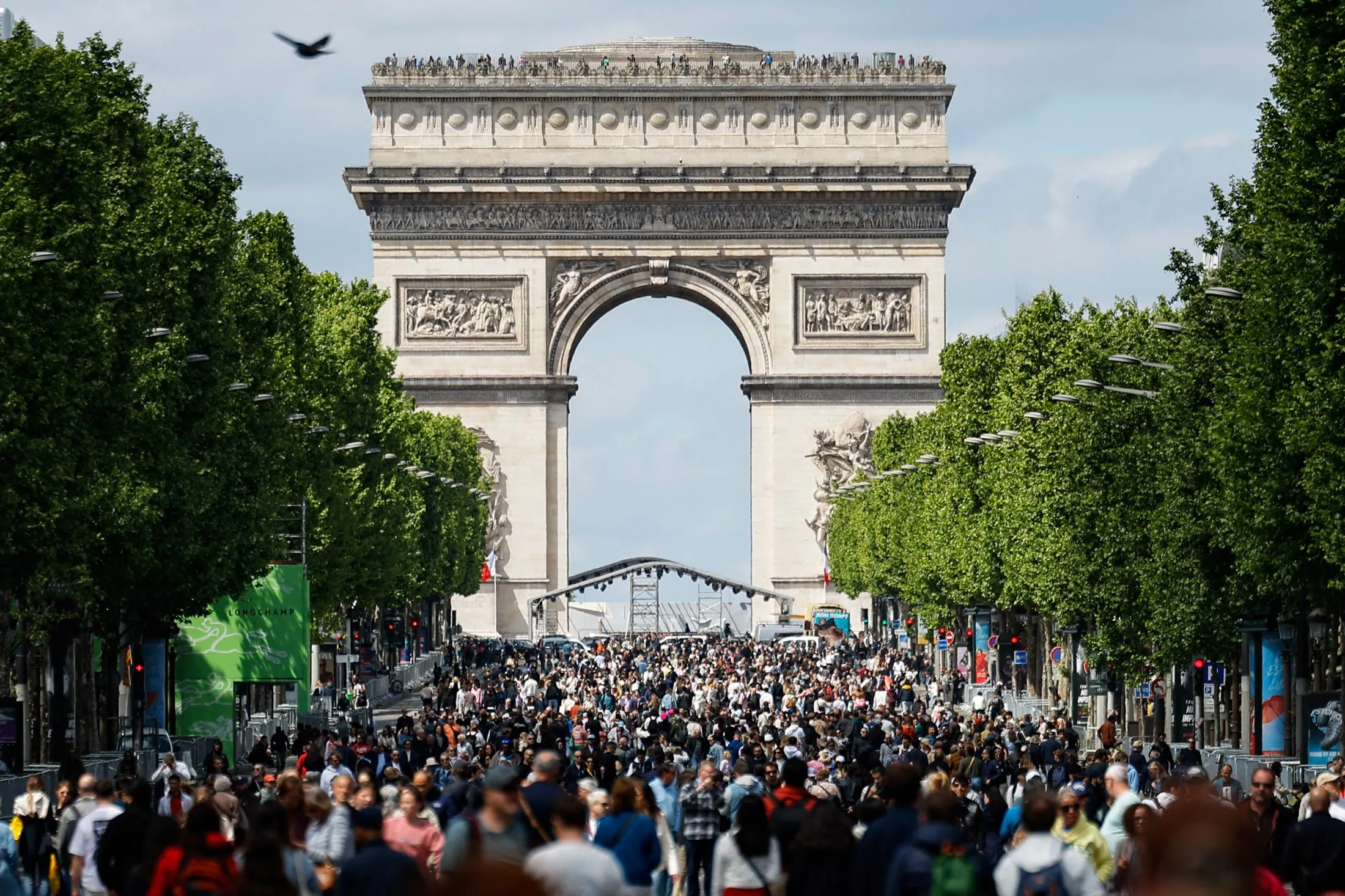 Pedestrians along the Champs-Elysees avenue and the Arc de Triomphe during a "car free" day in Paris on May 4, 2025.