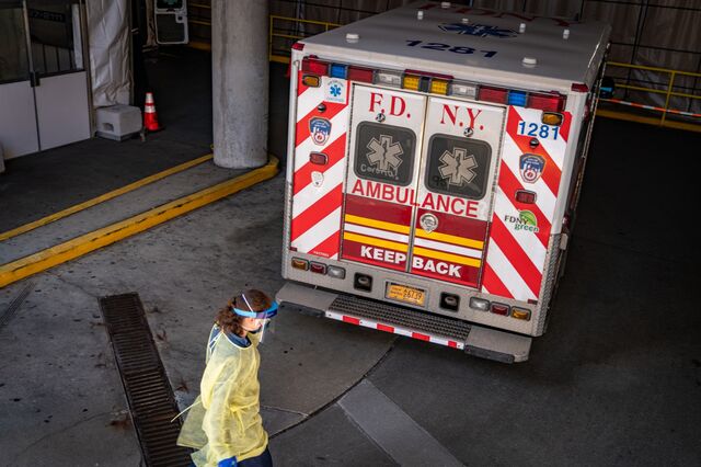 A medical worker wearing protective gear walks by a FDNY ambulance outside the emergency room at Montefiore Hospital in New York.