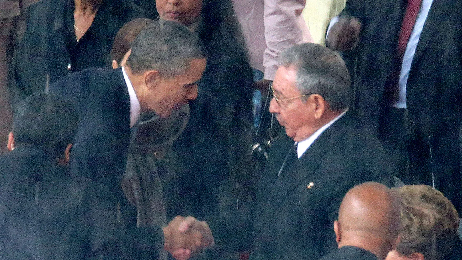 U.S. President Barack Obama (L) shakes hands with Cuban President Raul Castro during the official memorial service for former South African President Nelson Mandela at FNB Stadium December 10, 2013 in Johannesburg, South Africa.

