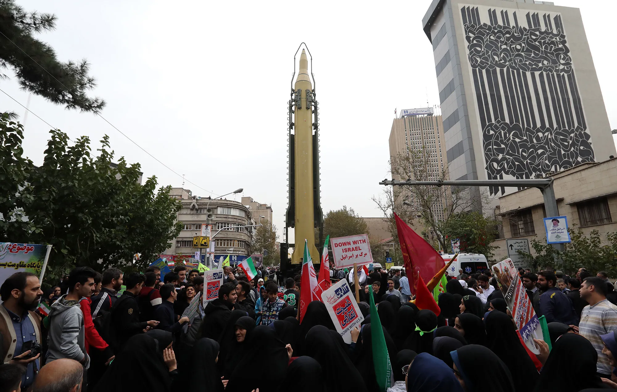 Iranians gather next to a replica of a Ghadr medium-range ballistic missile during a demonstration outside the former U.S. embassy in Tehran in 2017.&nbsp;