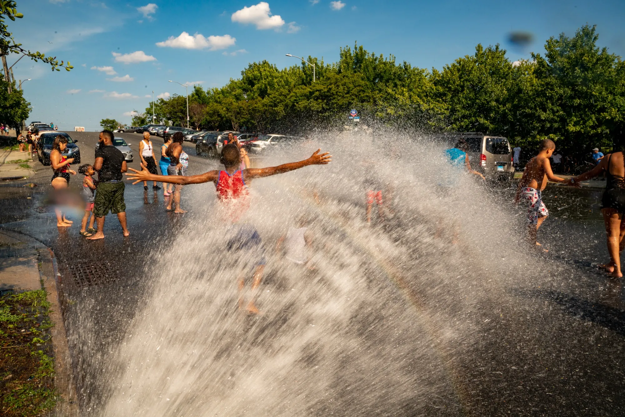 People stand in the spray of water from a fire hydrant in the Bronx,&nbsp;New York.