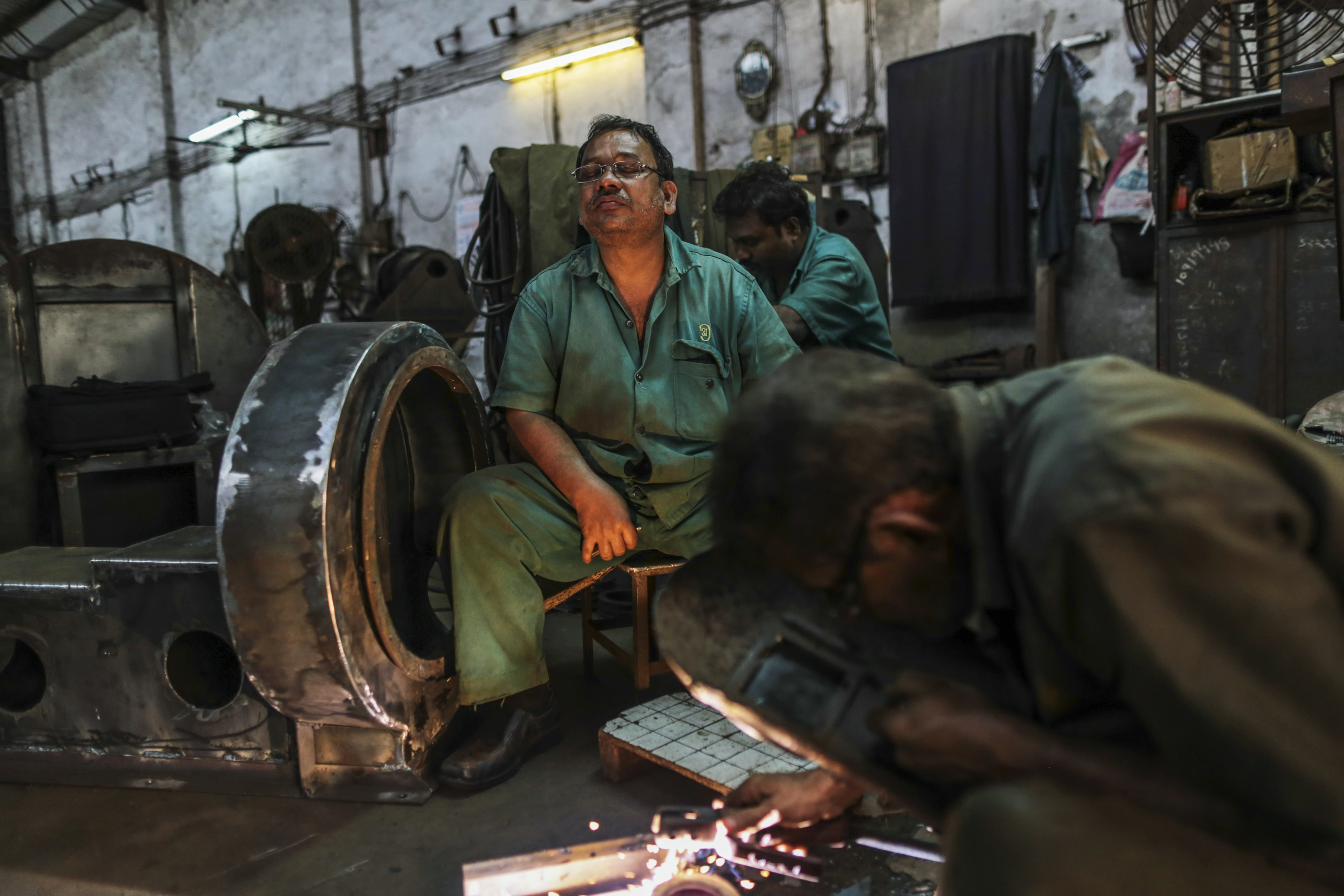 An employee pauses while working at a factory in Mumbai, Maharashtra, India, on Saturday, Feb. 7, 2015.
