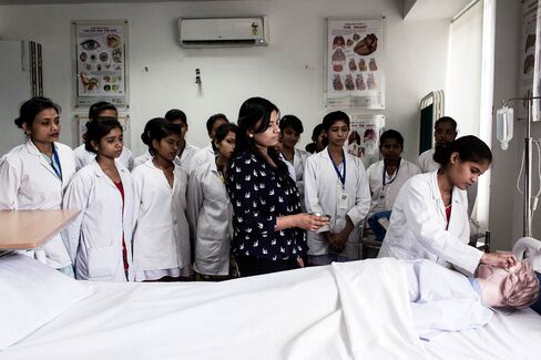 Students and a tutor, center, observe another student in a general duty assistant nursing class during vocational training at the Infrastructure Leasing & Financial Services Institute of Skills in New Delhi, India, on June 25. Prime Minister Narendra Modi is racing to change a skills shortage that affects professions across India, from truck drivers and cooks to engineers and airline technicians.