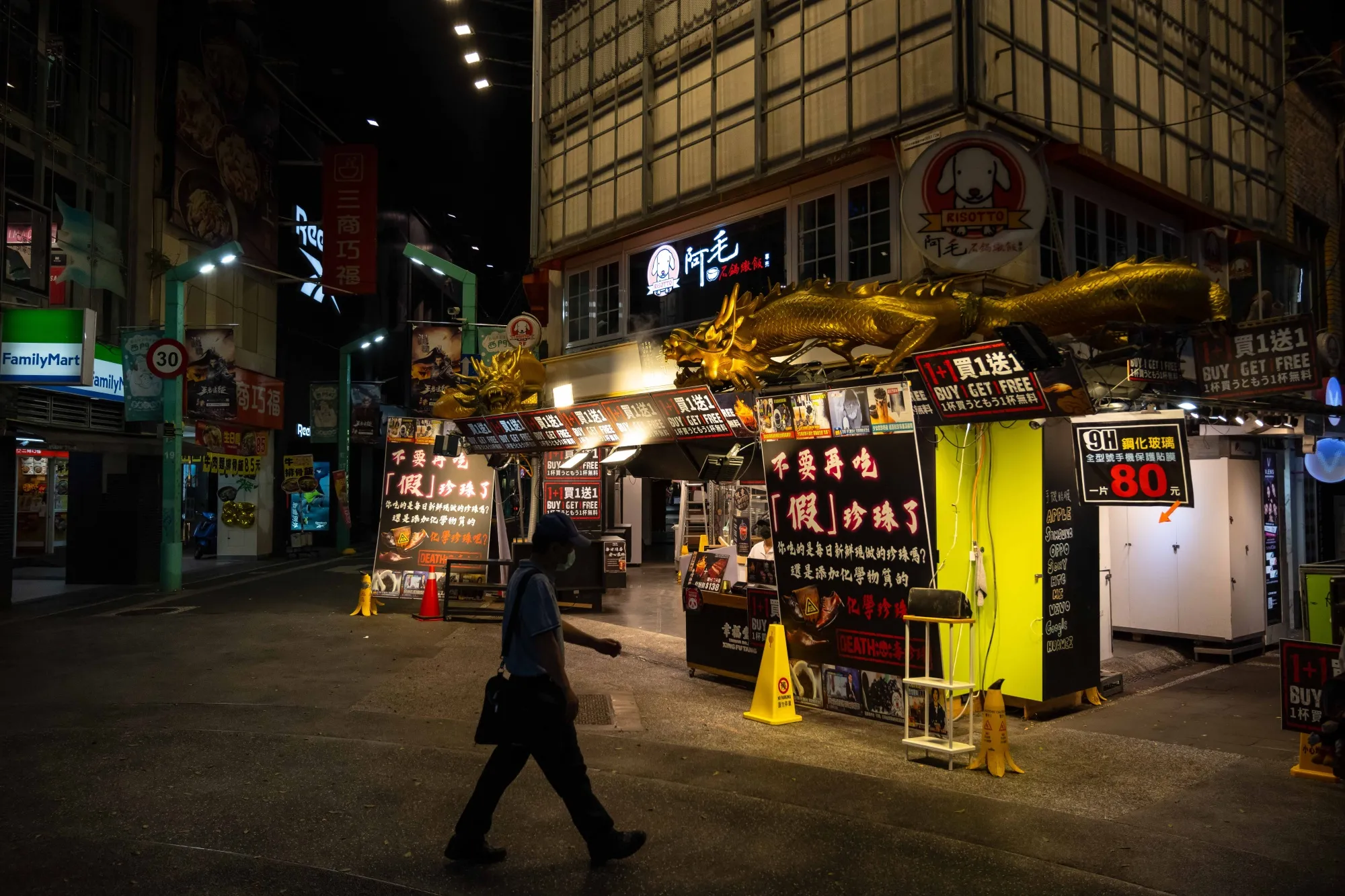 A pedestrian passes a restaurant on a deserted street in the Ximending district of Taiwan on May 17.