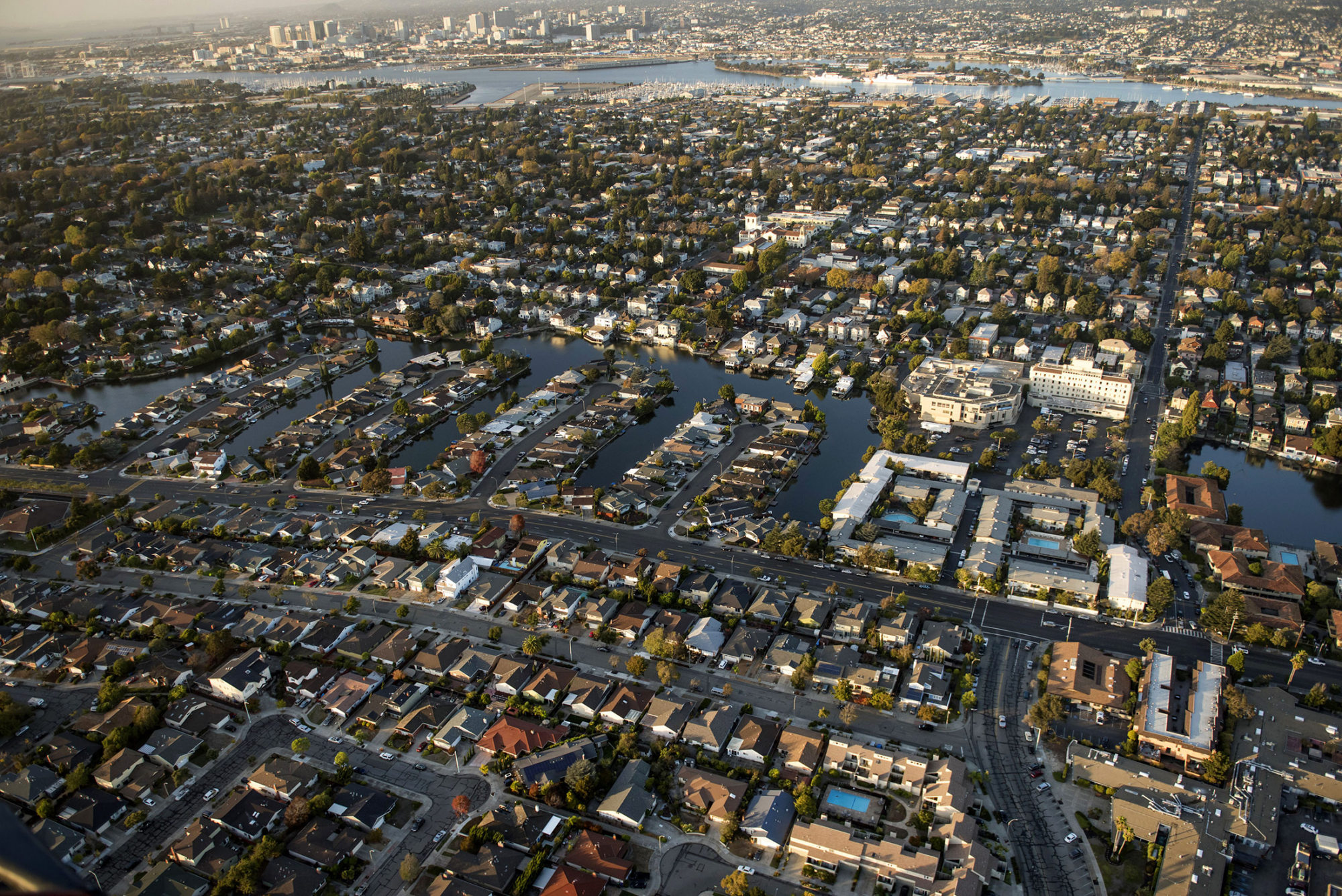 Houses stand in this aerial photograph taken above Alameda, California, U.S., on Monday, Oct. 5, 2015. With tech workers flooding San Francisco, one-bedroom apartment rents have climbed to $3,500 a month, more than in any other U.S. city.
