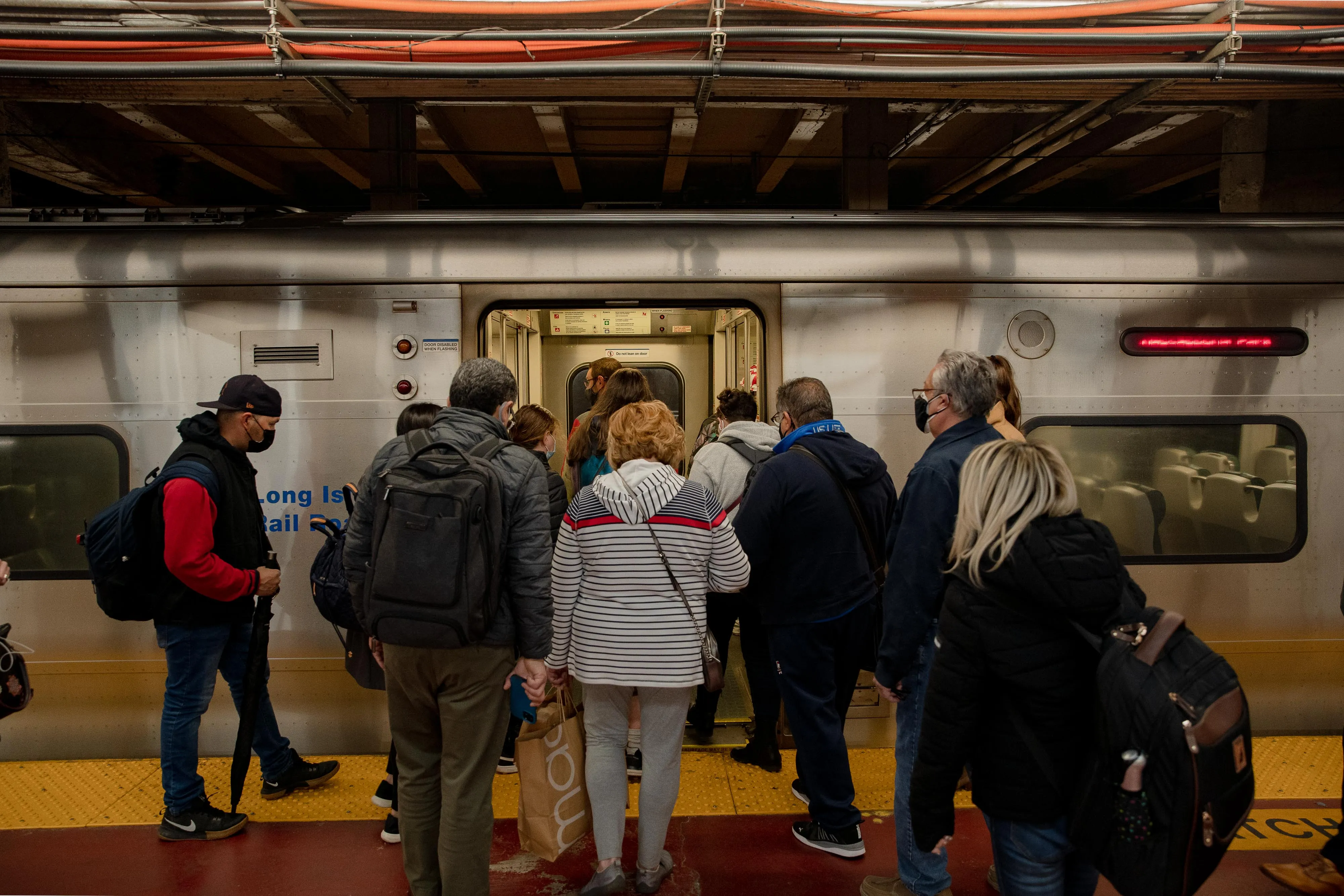 Commuters board a Long Island Rail Road train at Penn Station in New York.