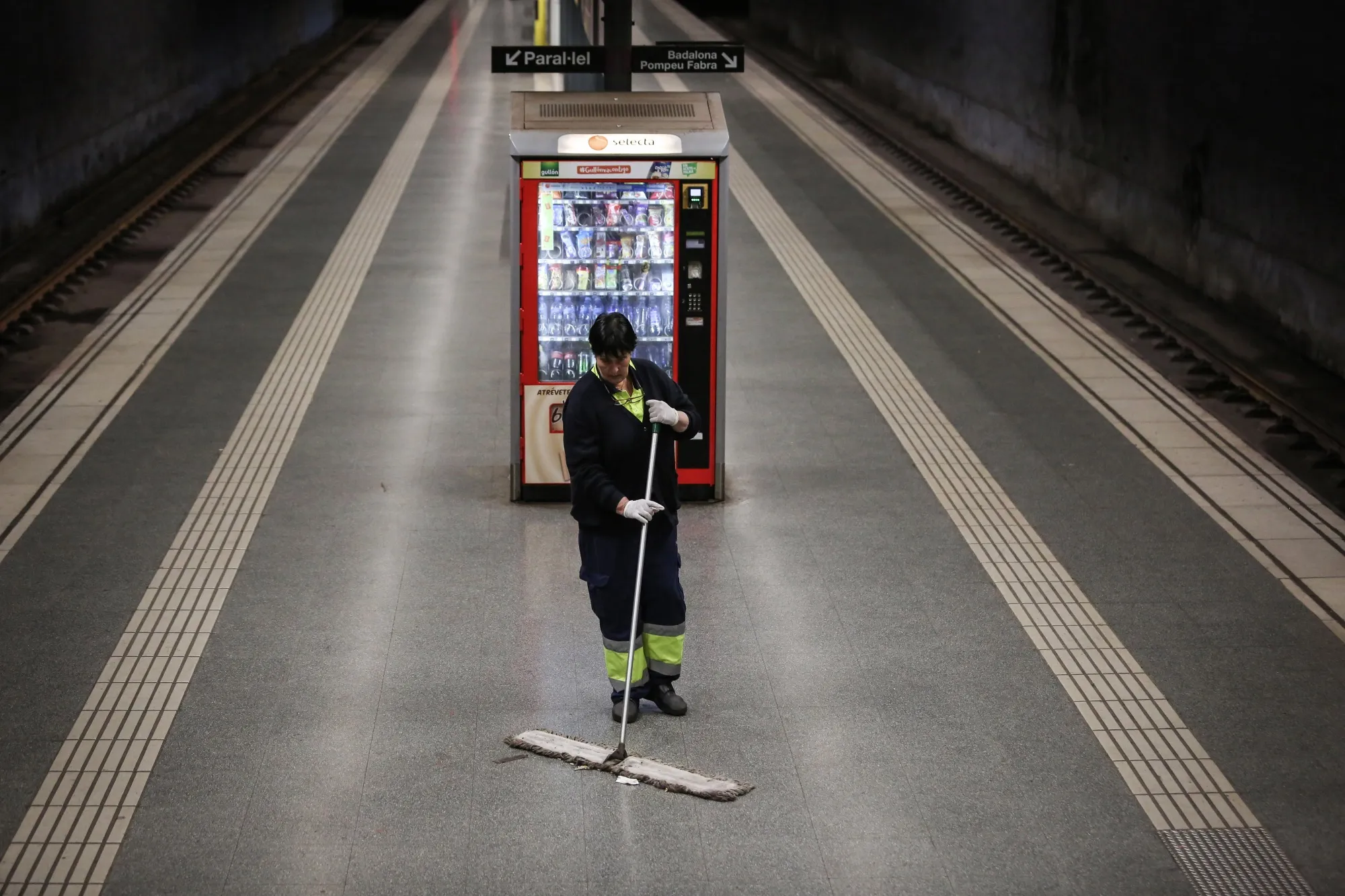 A municipal cleaner sweeps a deserted platform at the Sant Antoni metro station in Barcelona, Spain, on&nbsp;April 14.