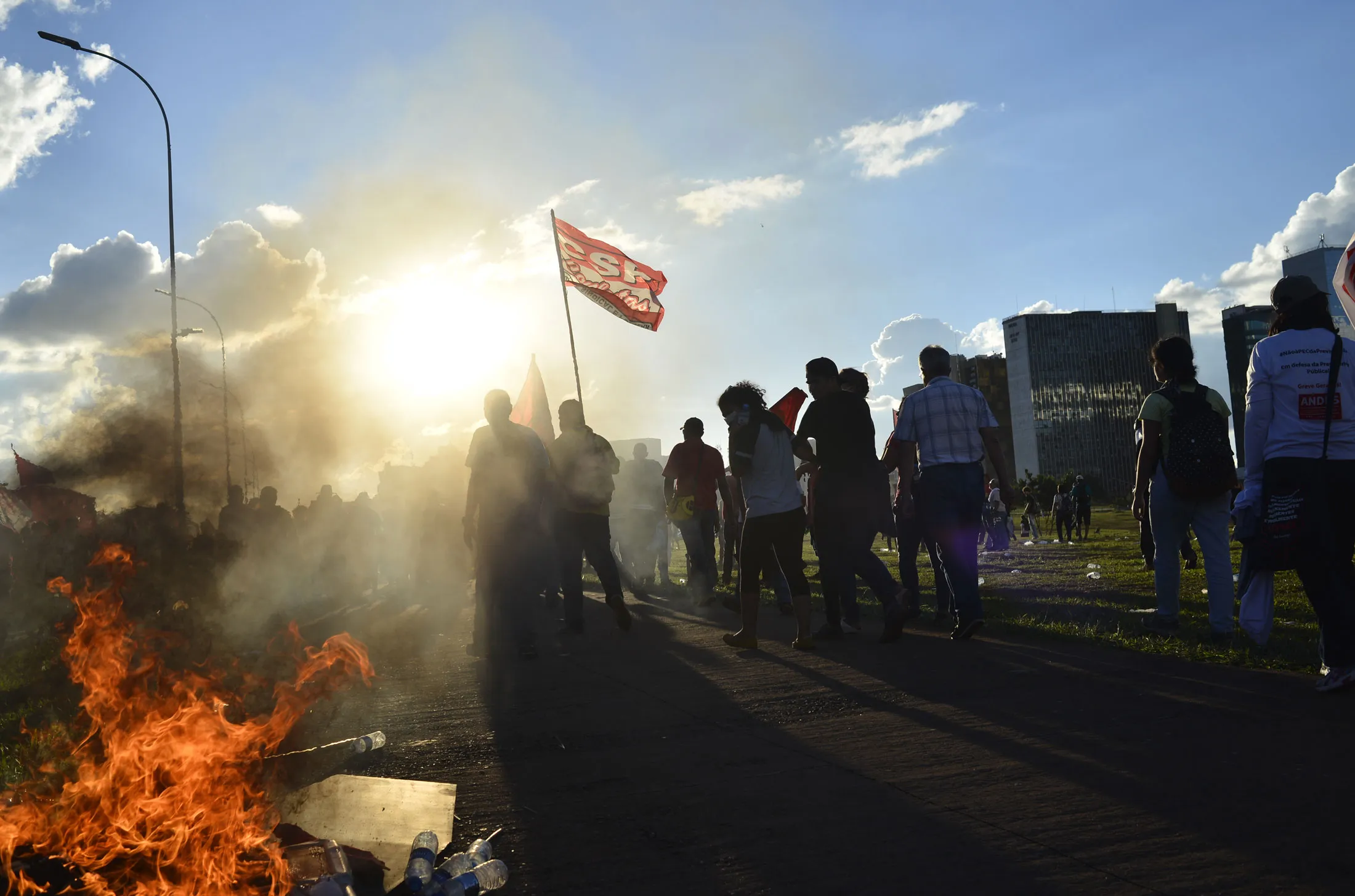 Demonstrators pass a fire during a protest in Brasilia, Brazil, on Wednesday, May 24, 2017.
