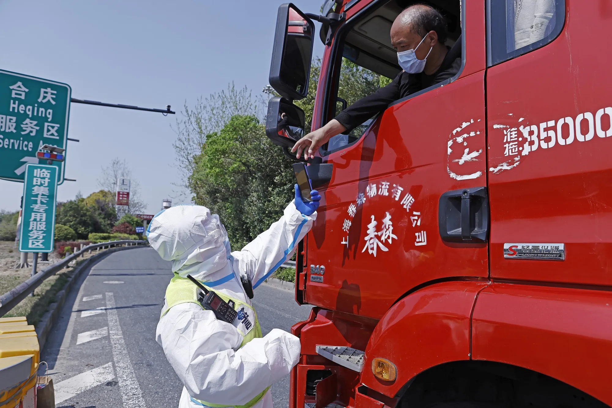 A driver presents his negative nucleic acid test certificate to a traffic police officer in Shanghai, on April 11.