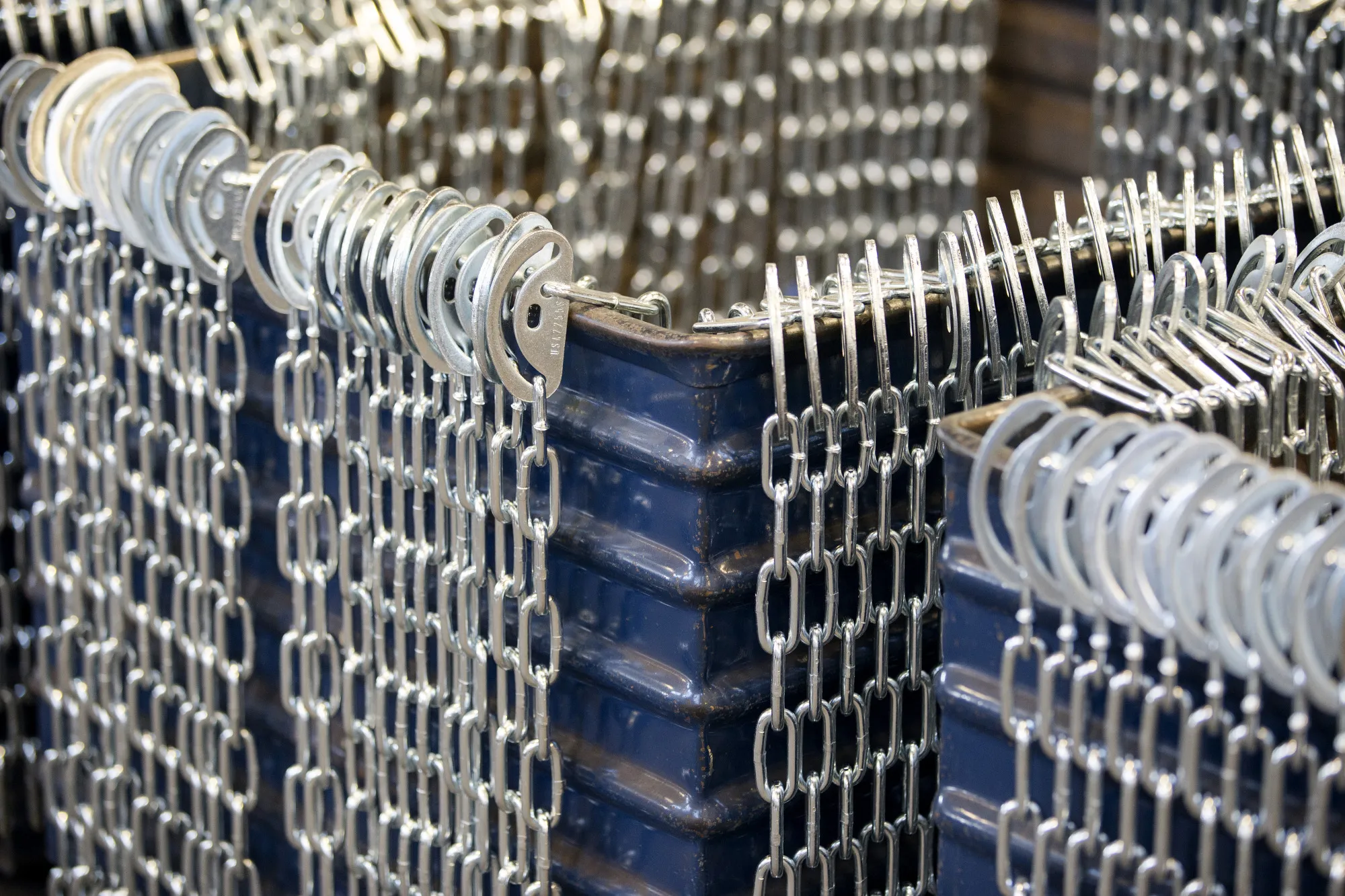 Chains hang from a bin during production at a chain manufacturing facility in Pueblo, Colorado.