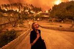 A resident flees the village of Gouves, on the island of Evia, Greece, on Sunday, Aug. 8, 2021. Elevated risk of fires is just one of the effects of climate change being felt all over the world.