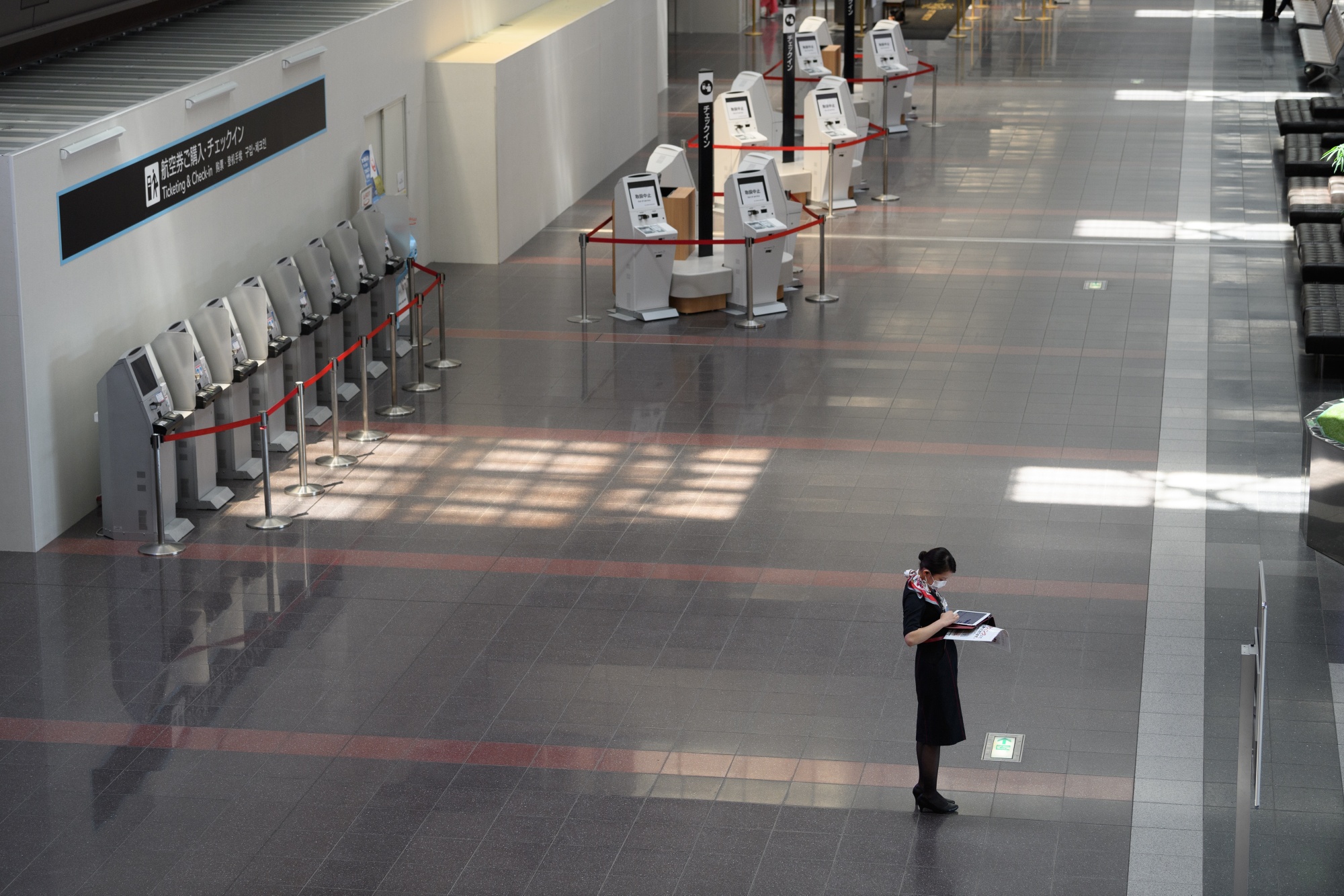 A JAL employee at Haneda Airport’s check-in area in April.