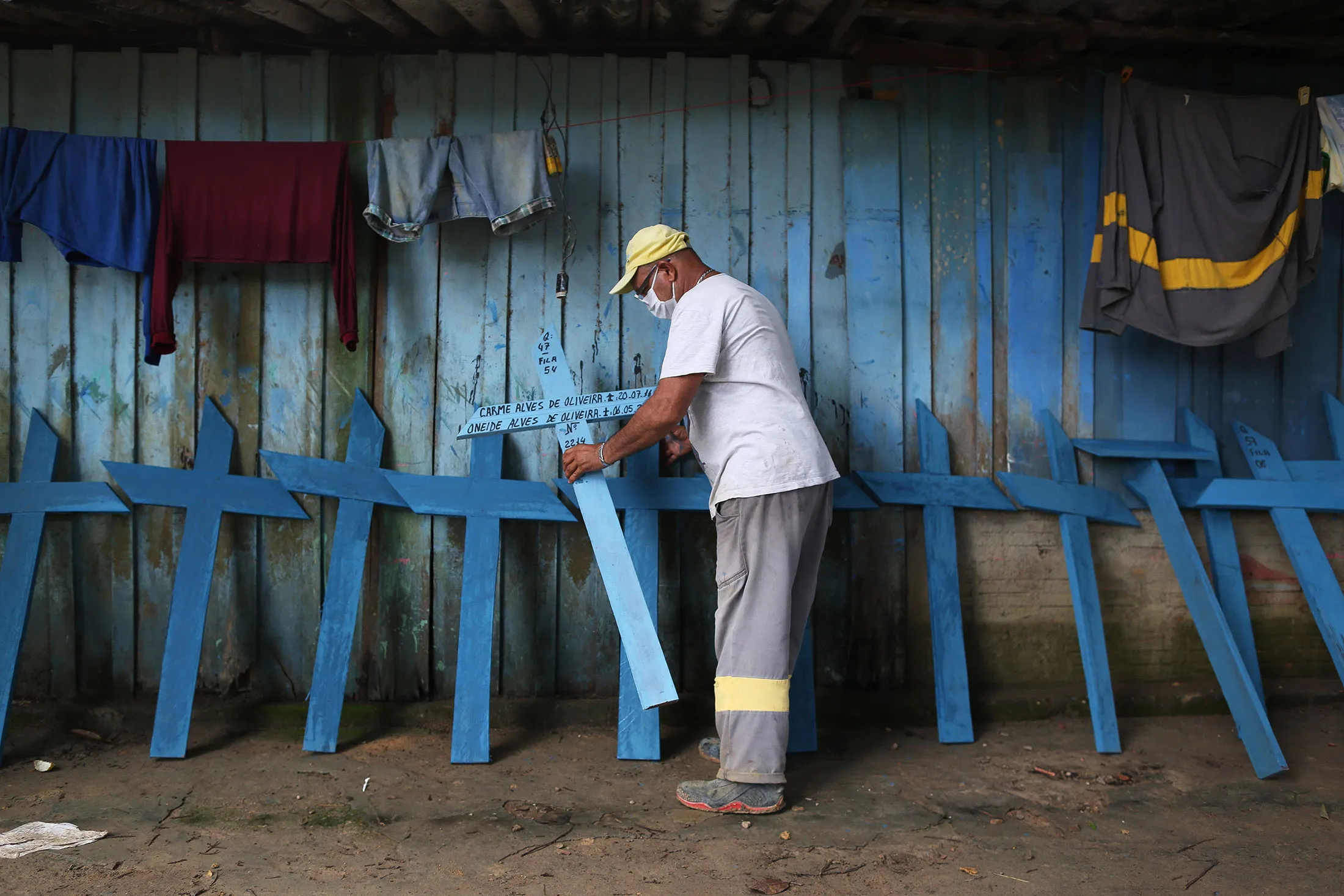 A worker places hand-made crosses along a wall in&nbsp;Manaus, Brazil, on&nbsp;May 7.