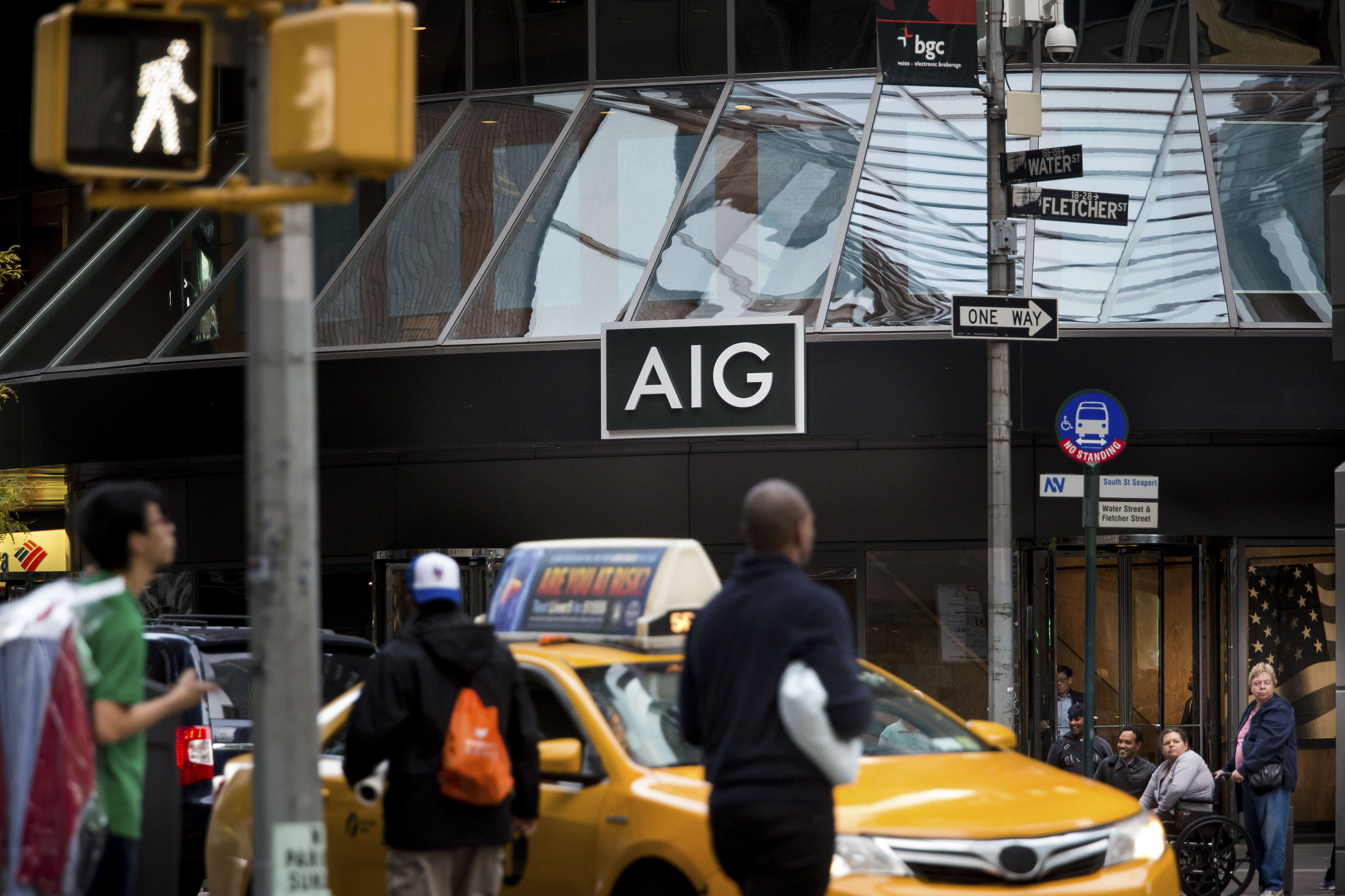 Pedestrians walk near the American International Group Inc. (AIG) headquarters in New York.&nbsp;