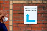 A woman walks past a sign guiding people to the entrance of a corona testing station in Berlin, on March 13. 