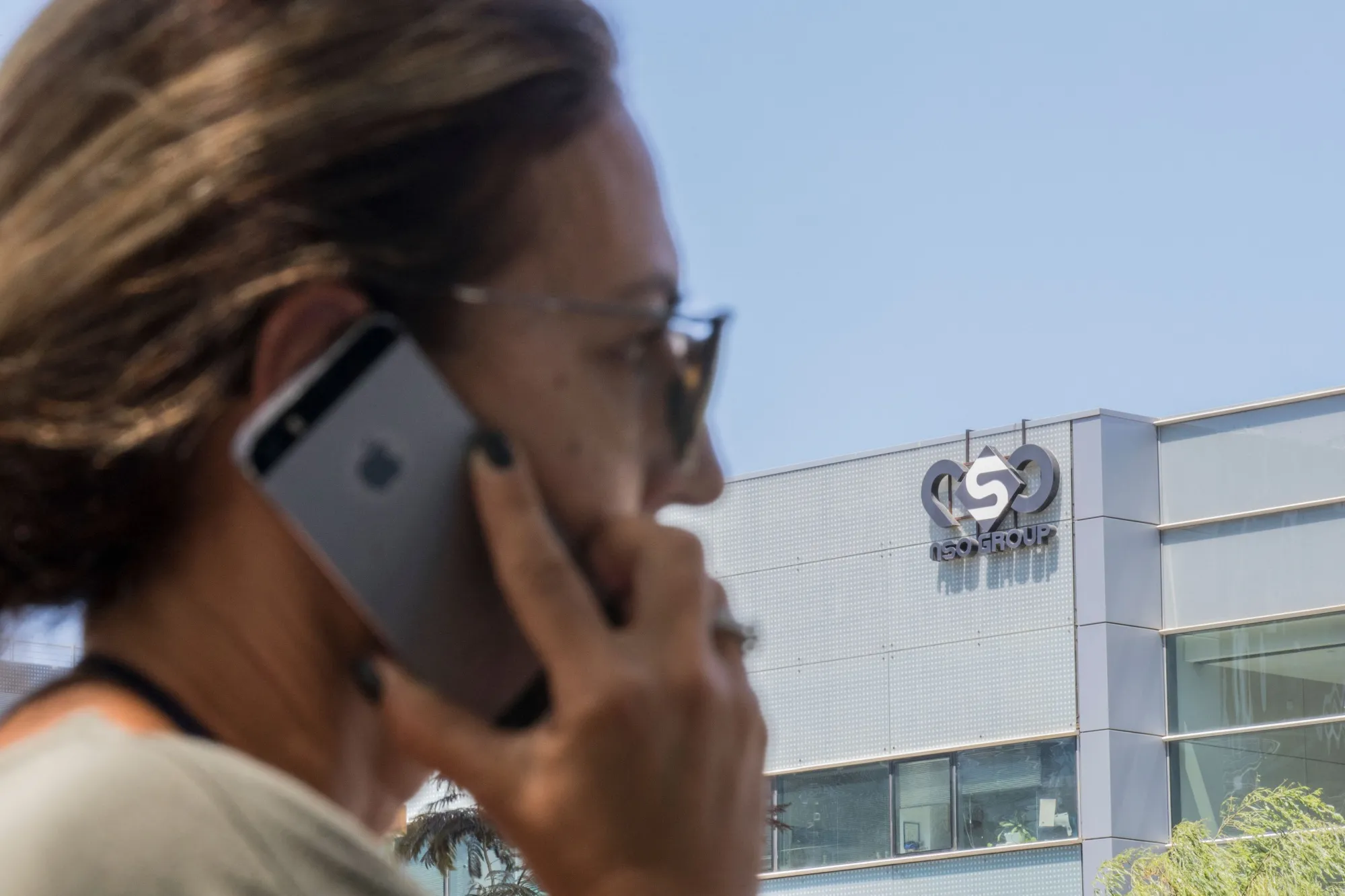 An Israeli woman uses her iPhone in front of the offices of Israel-based&nbsp;NSO Group in Herzliya, near Tel Aviv.