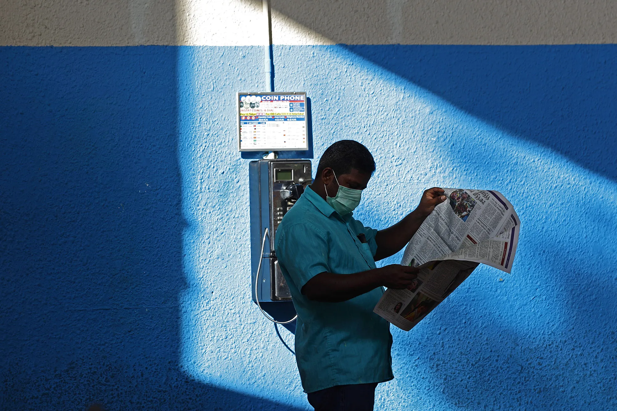 A man reads a newspaper after stricter measures to contain the spread of coronavirus were announced, in Singapore on April 4.