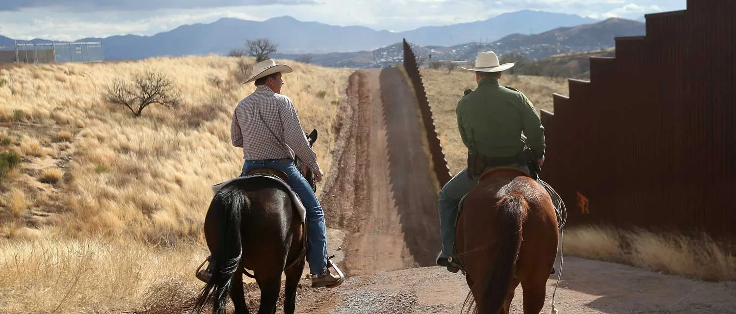 U.S. Border Patrol ranch liaison John 'Cody' Jackson (R) rides with cattle rancher Dan Bell on Bell's ZZ Cattle Ranch at the U.S.-Mexico border on March 8, 2013 in Nogales, Arizona. Jackson meets regularly with local ranchers to coordinate the agency's efforts on border issues, including drug smuggling and illegal immigration from Mexico. Bell, a third generation rancher, grazes cattle on nearly ten miles of border property.
