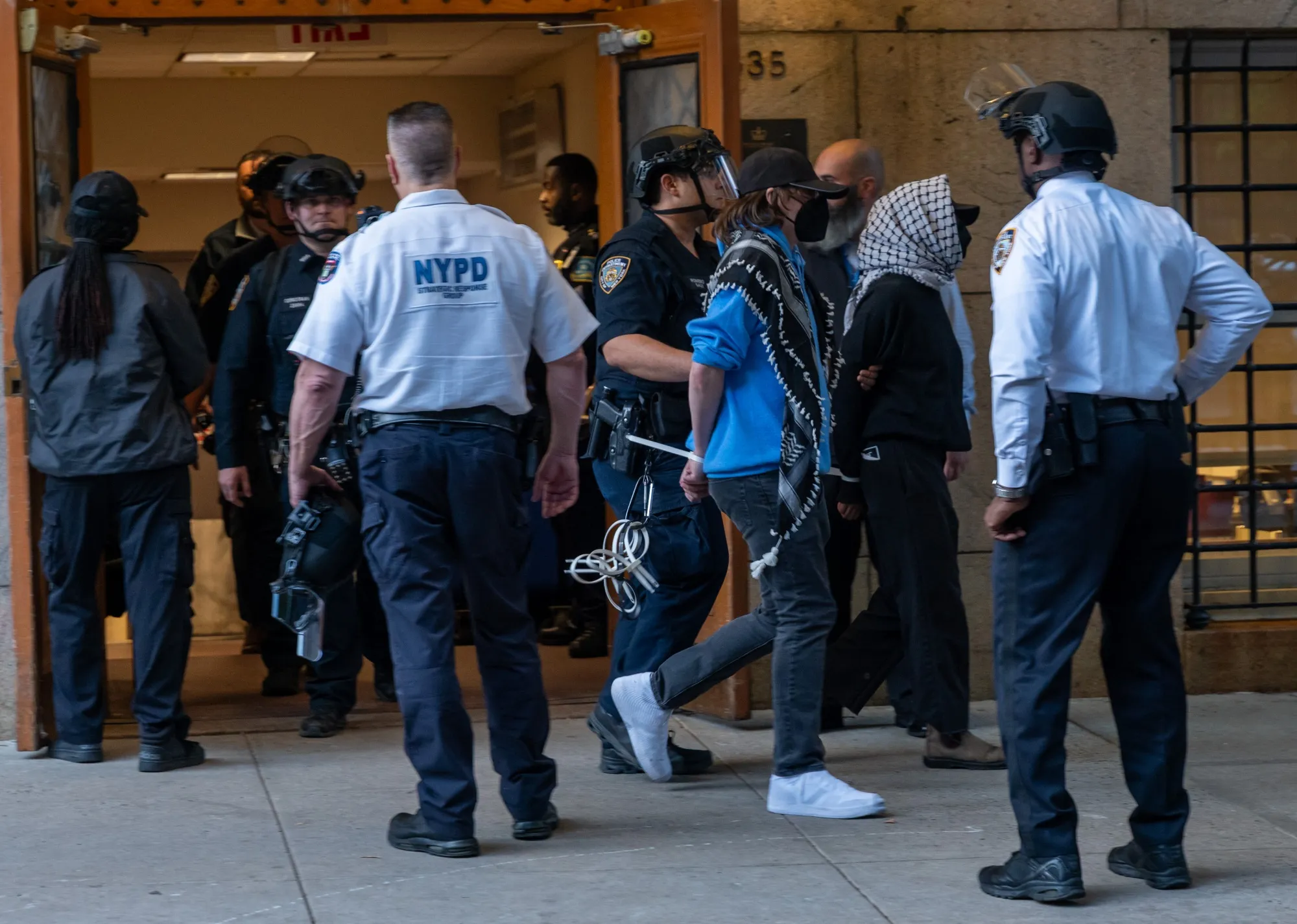 Protesters are escorted out of Columbia University's Butler Library after their arrest for occupying the library space in New York City, on May 7.&nbsp;