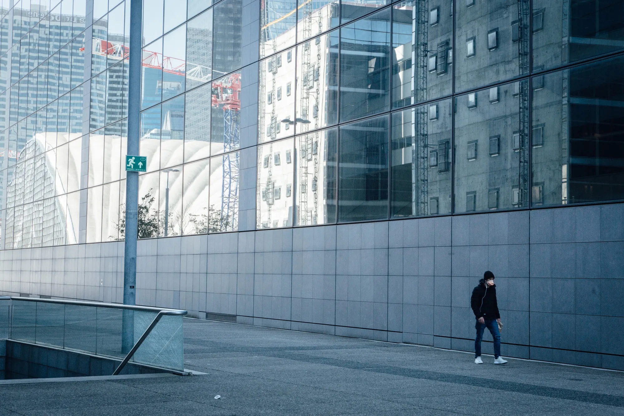 A pedestrian wearing a protective face mask passes skyscrapers&nbsp;in Paris, France, on March 24.&nbsp;