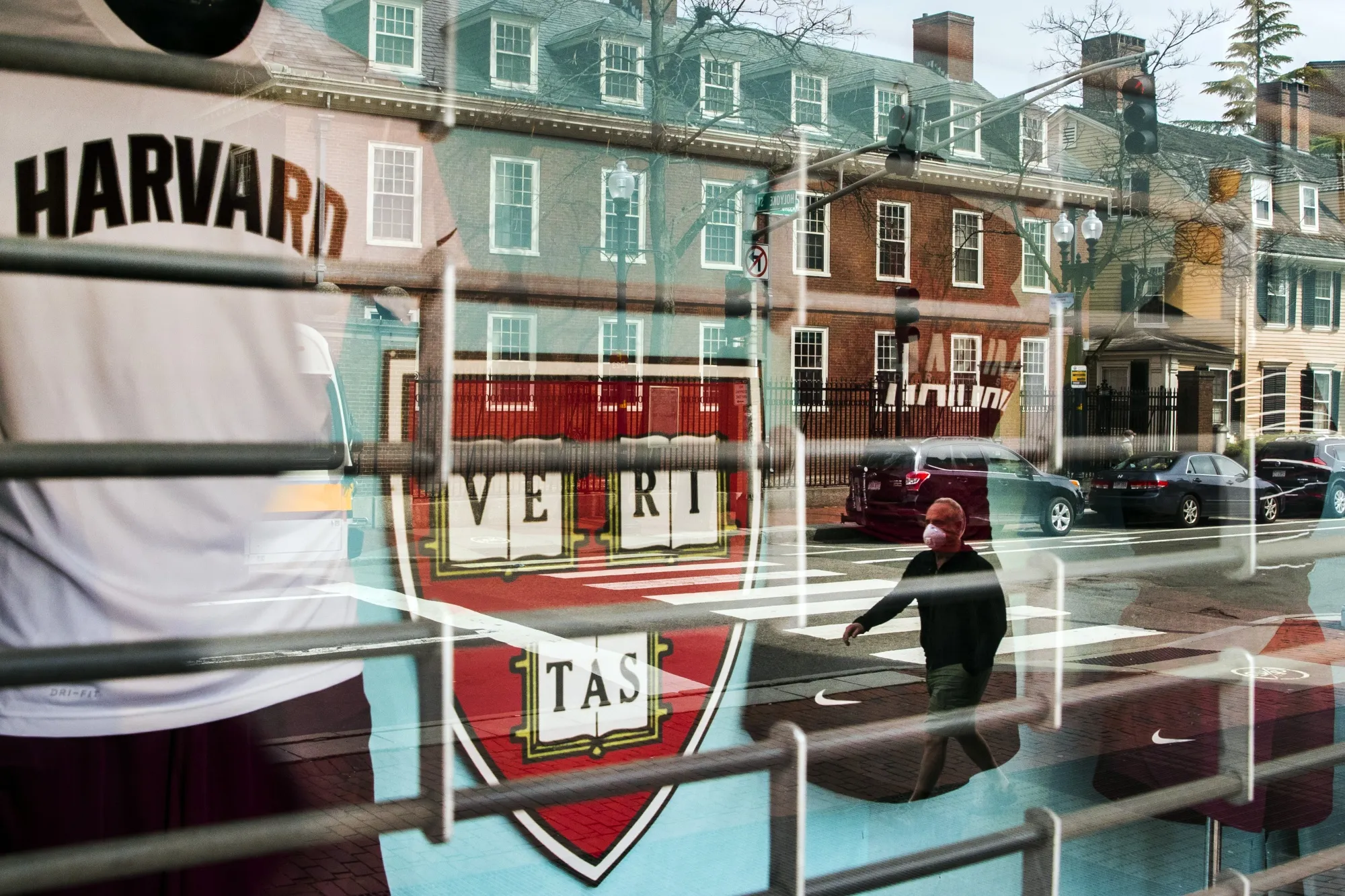 A pedestrian&nbsp;is reflected in the window of a Harvard University store in Cambridge, Mass.