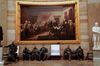 National Guard officers rest under a painting by John Trumbull of the Declaration of Independence being presented