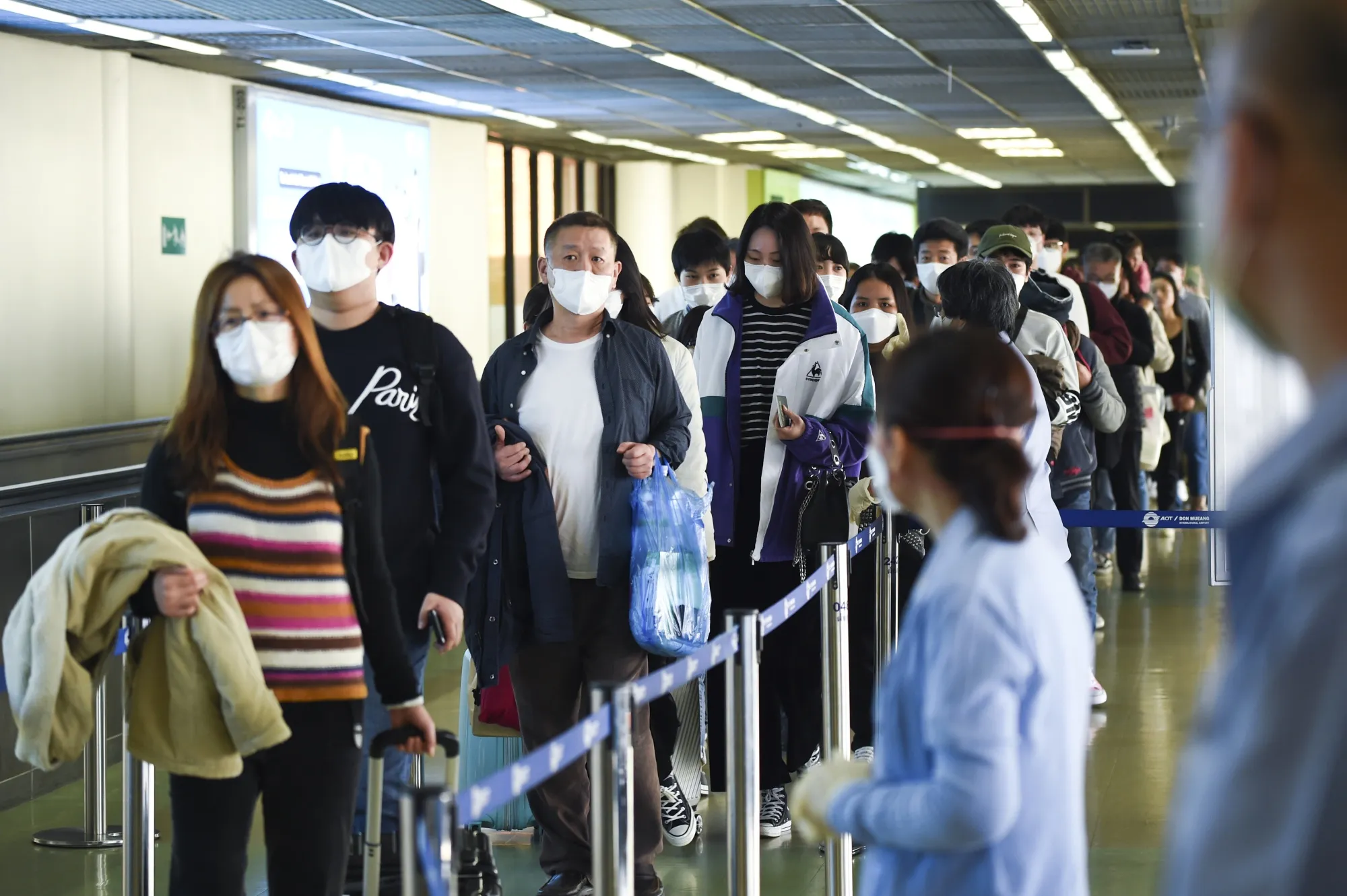 Tourists wear masks at Don Mueang Airport, in Bangkok, Feb. 2020.