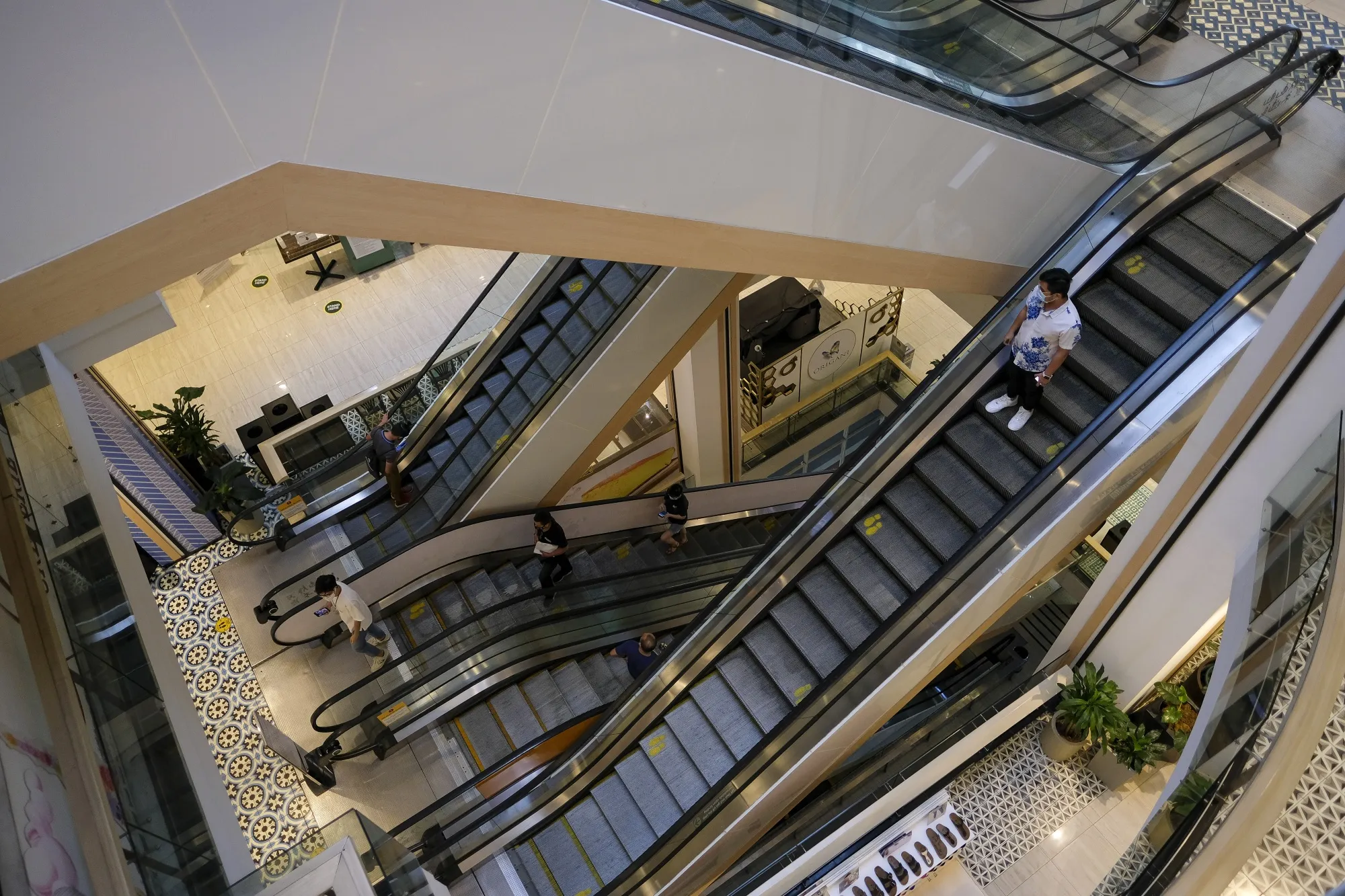Customers wearing protective masks ride on escalators inside a mall in Quezon City, Metro Manila, the Philippines, on&nbsp;June 22.&nbsp;