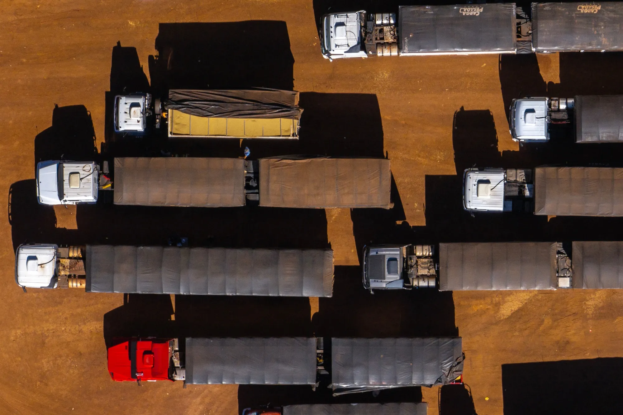 Trucks queue to load soy from a Cargill Inc. warehouse near Silvania, Goias state, Brazil, in February.