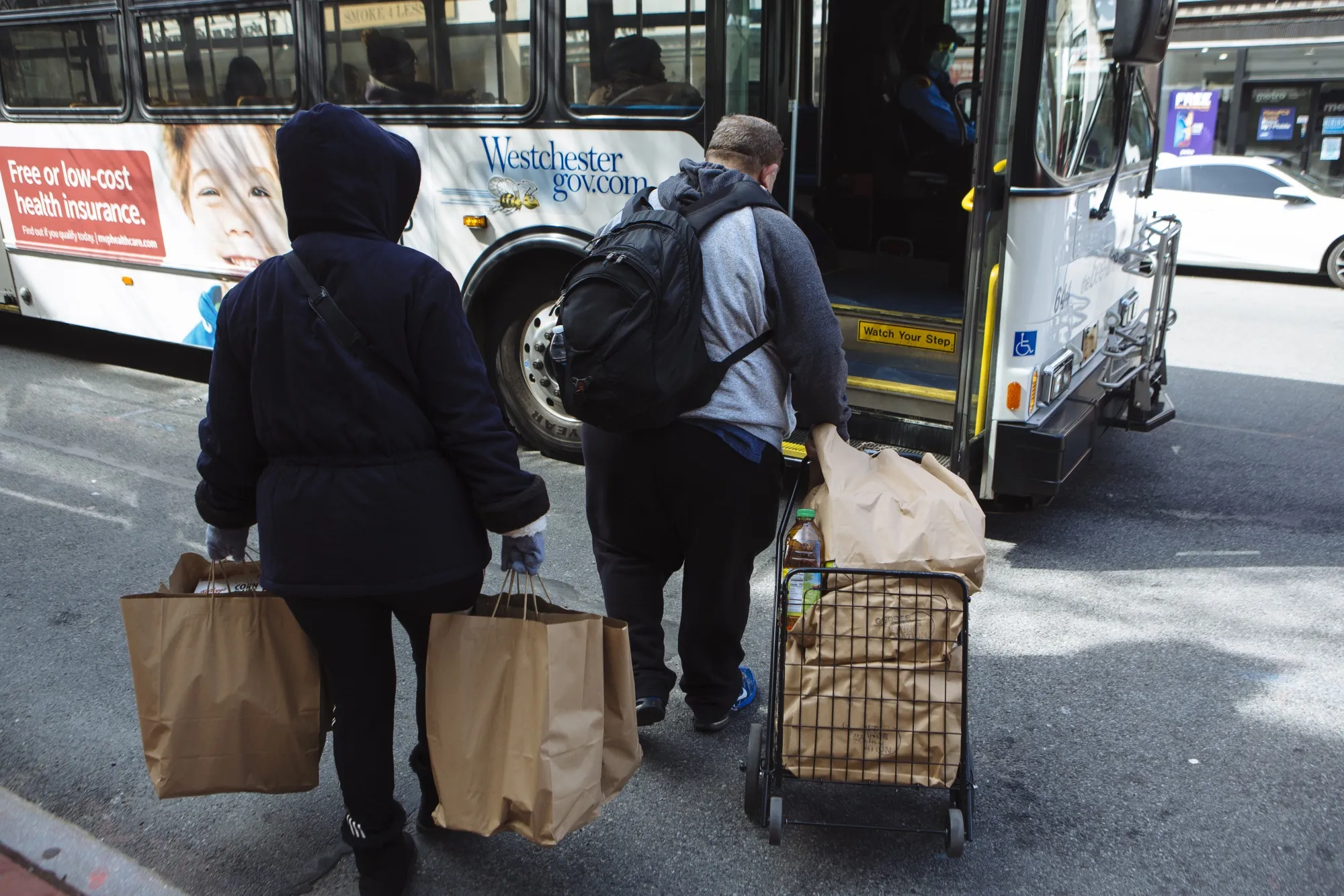Residents carrying grocery bags board a bus in New Rochelle, New York, on&nbsp;March 16.