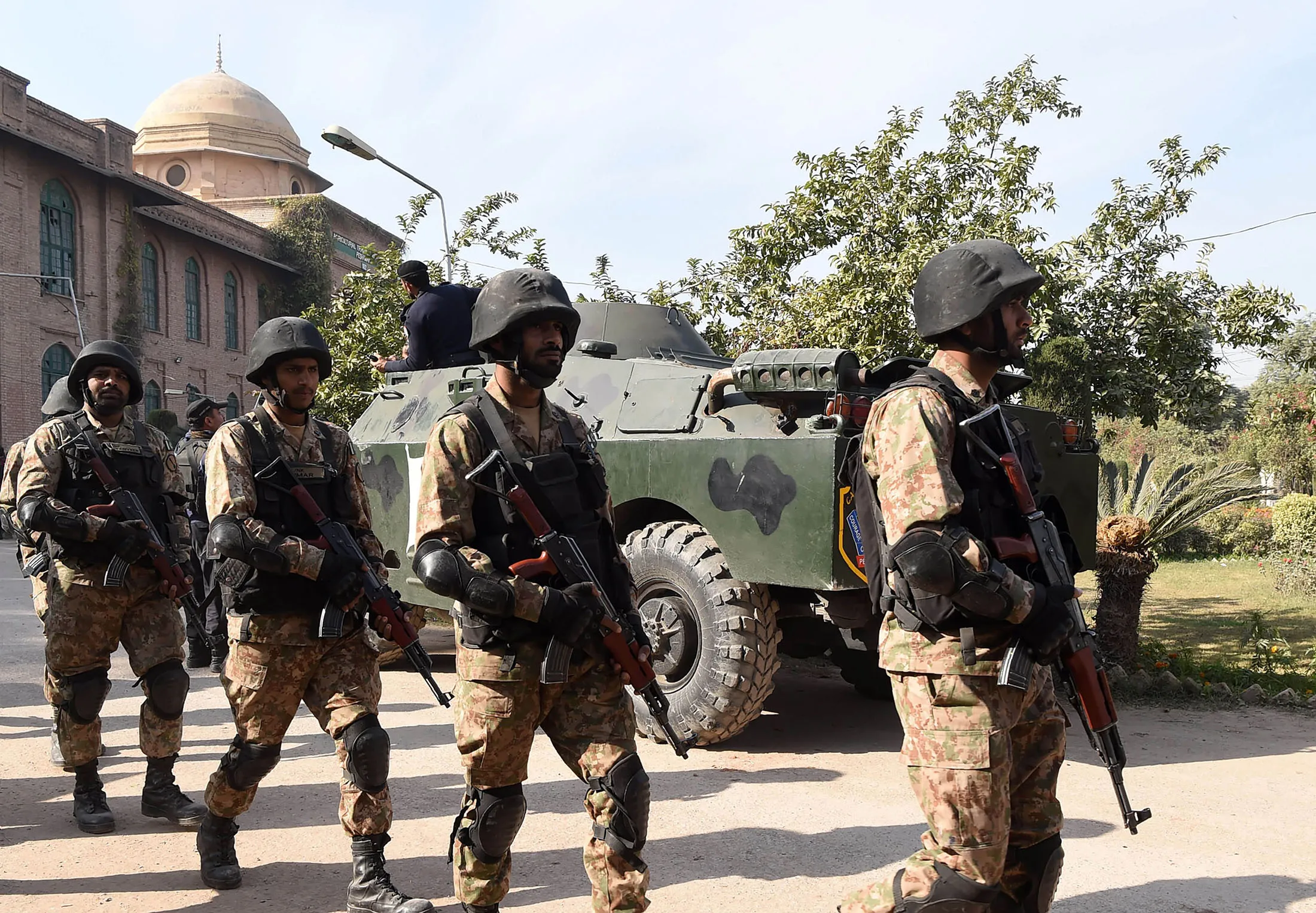 Pakistani soldiers walk at the premises of an Agriculture Training Institute after an attack by Taliban militants in Peshawar on December 1, 2017.Nine people were killed and dozens injured on December 1 when Taliban militants stormed a training institute in the northwestern city of Peshawar as Pakistan marked the birthday of the Prophet Mohammed, officials said. / AFP PHOTO / ABDUL MAJEED        (Photo credit should read ABDUL MAJEED/AFP/Getty Images)