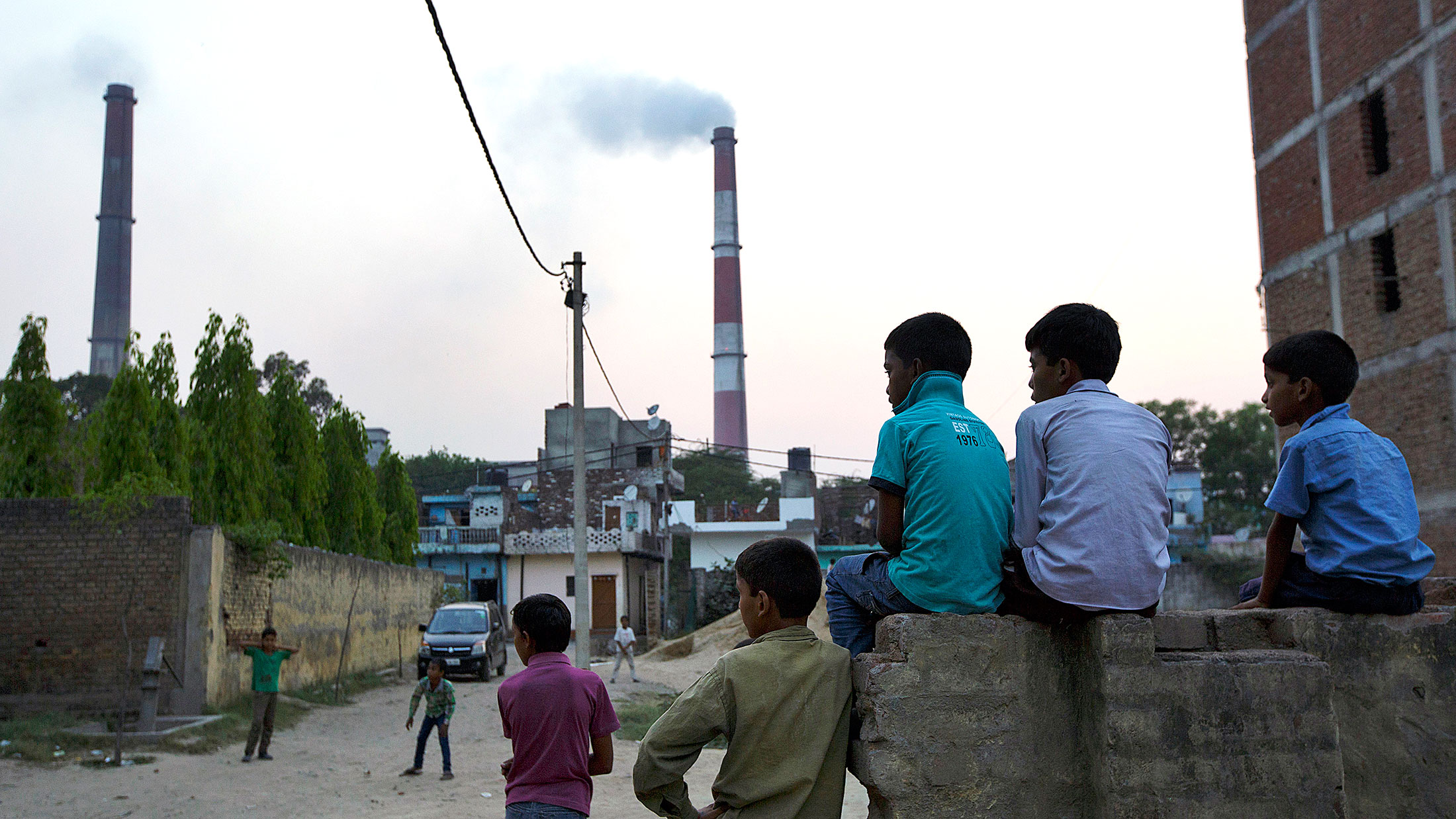 Emissions billow from smokestacks at a coal-fired power plant near residential property in Badarpur, India.
