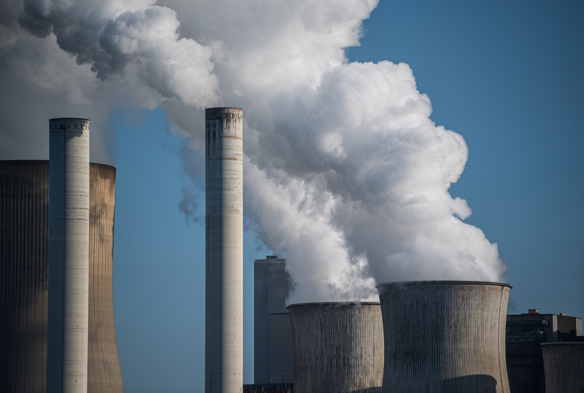 Steam rises from cooling towers at a coal-fired power plant near Bergheim, Germany. Photographer: Lukas Schulze/Getty Images