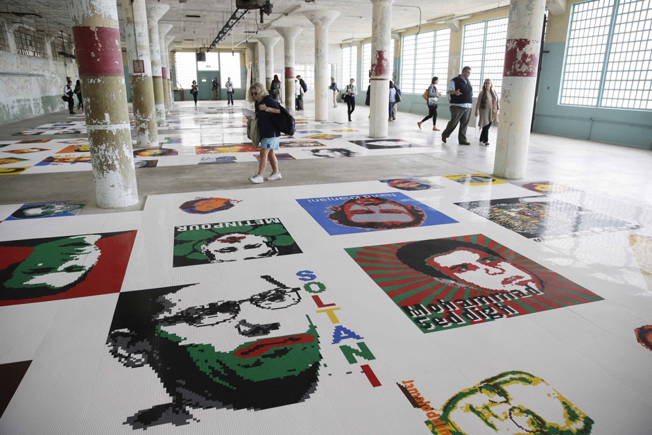 Viewers examine 175 portraits of dissidents made with Legos by Ai Weiwei for a 2014 exhibition at Alcatraz Island in San Francisco.