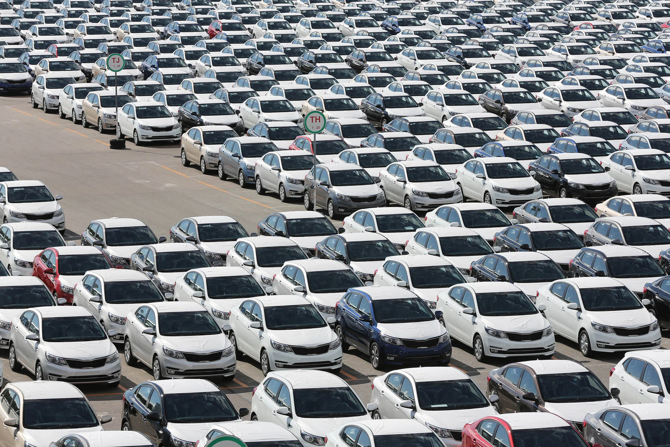 Completed Kia Rio vehicles sit with body panels covered in protective wrapping ahead of distribution in a parking lot outside the Hyundai Motors Corp. automobile plant in St Petersburg, Russia, on Friday, Aug. 14, 2015. By volume, Hyundai Kia is the largest automaker in Russia, holding that position as its 15% decline in unit year-to-date sales is the third best performance of all automakers selling in Russia.
