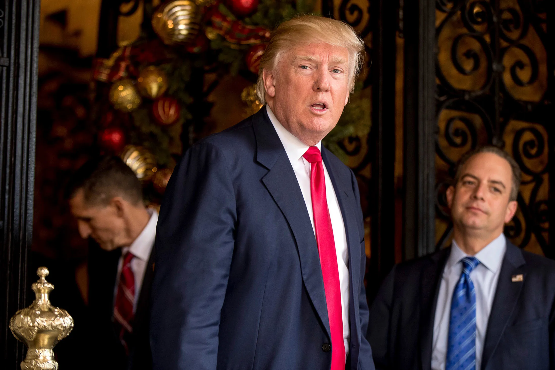 President-elect Donald Trump, center, accompanied by Trump Chief of Staff Reince Priebus, right, and Retired Gen. Michael Flynn, a senior adviser to President-elect Donald Trump, left, speaks to members of the media at Mar-a-Lago, in Palm Beach, Fla., on Dec. 21, 2016.
