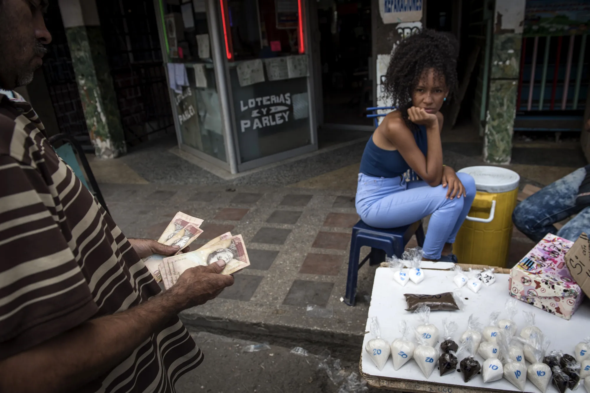A customer buys bags of coffee and sugar at a stand in Caracas.