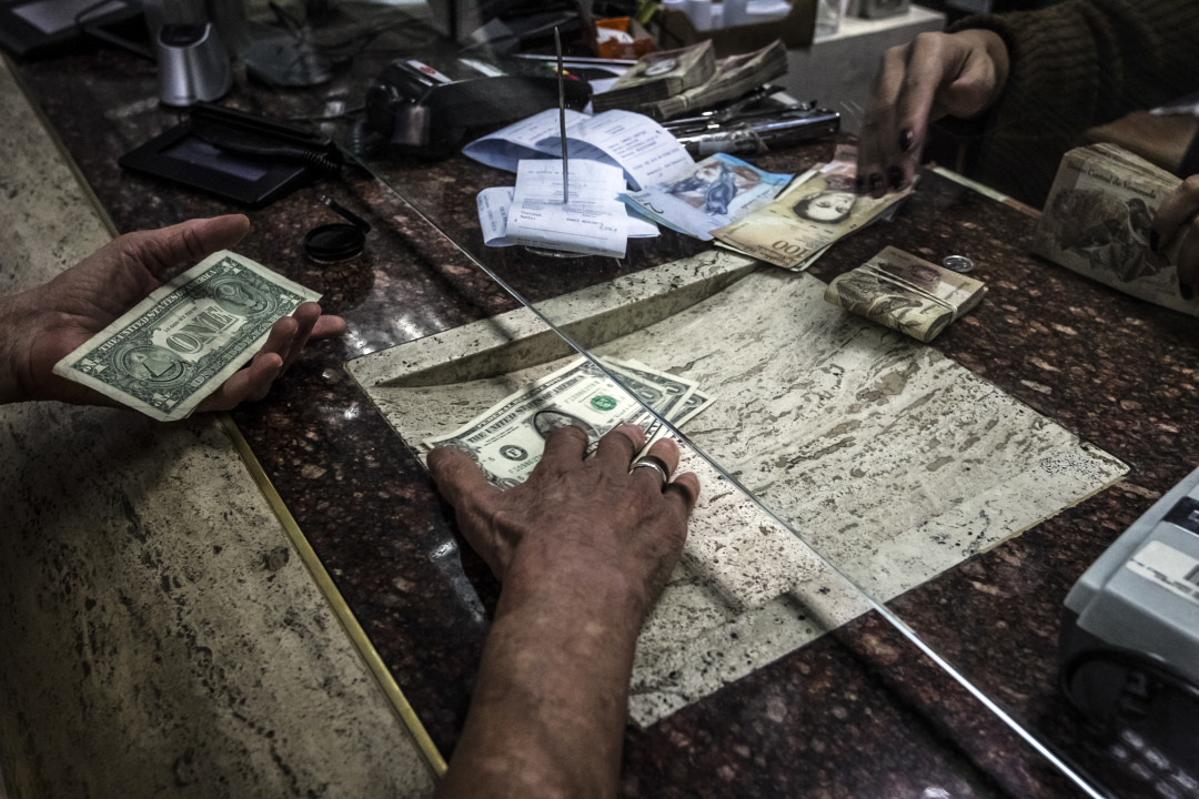 A customer receives U.S. dollars during a transaction in Caracas, Venezuela.