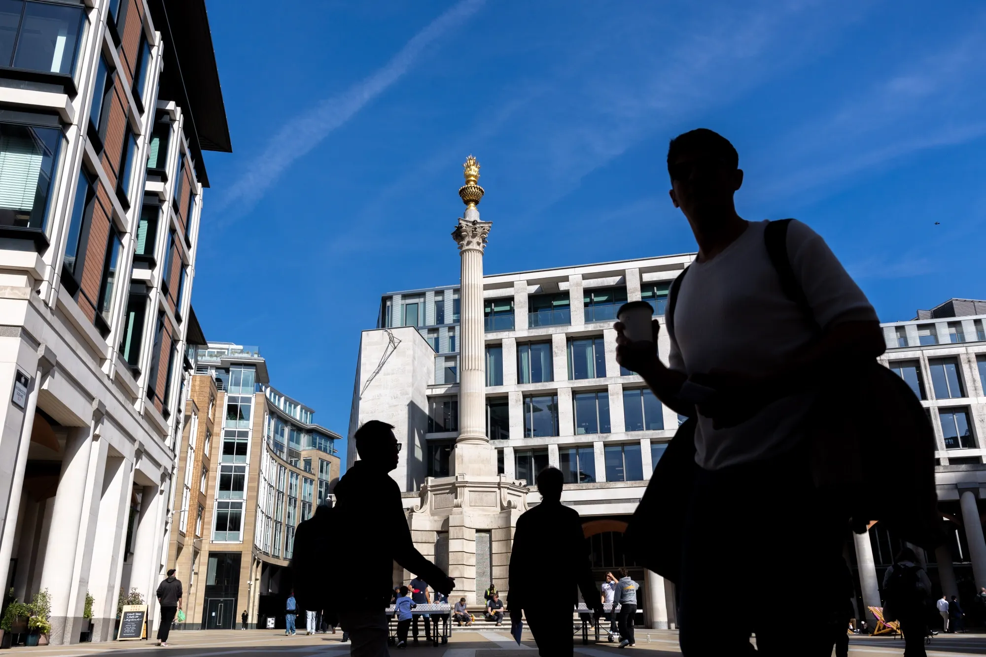 Commuters pass the London Stock Exchange.