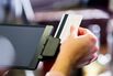 Hand of woman sliding credit card through reader