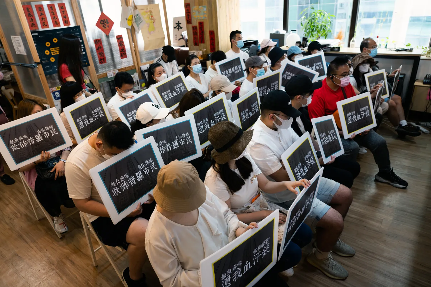 Florence Mok, front second left, and other buyers of the Vertex hold protests signs on May 14.