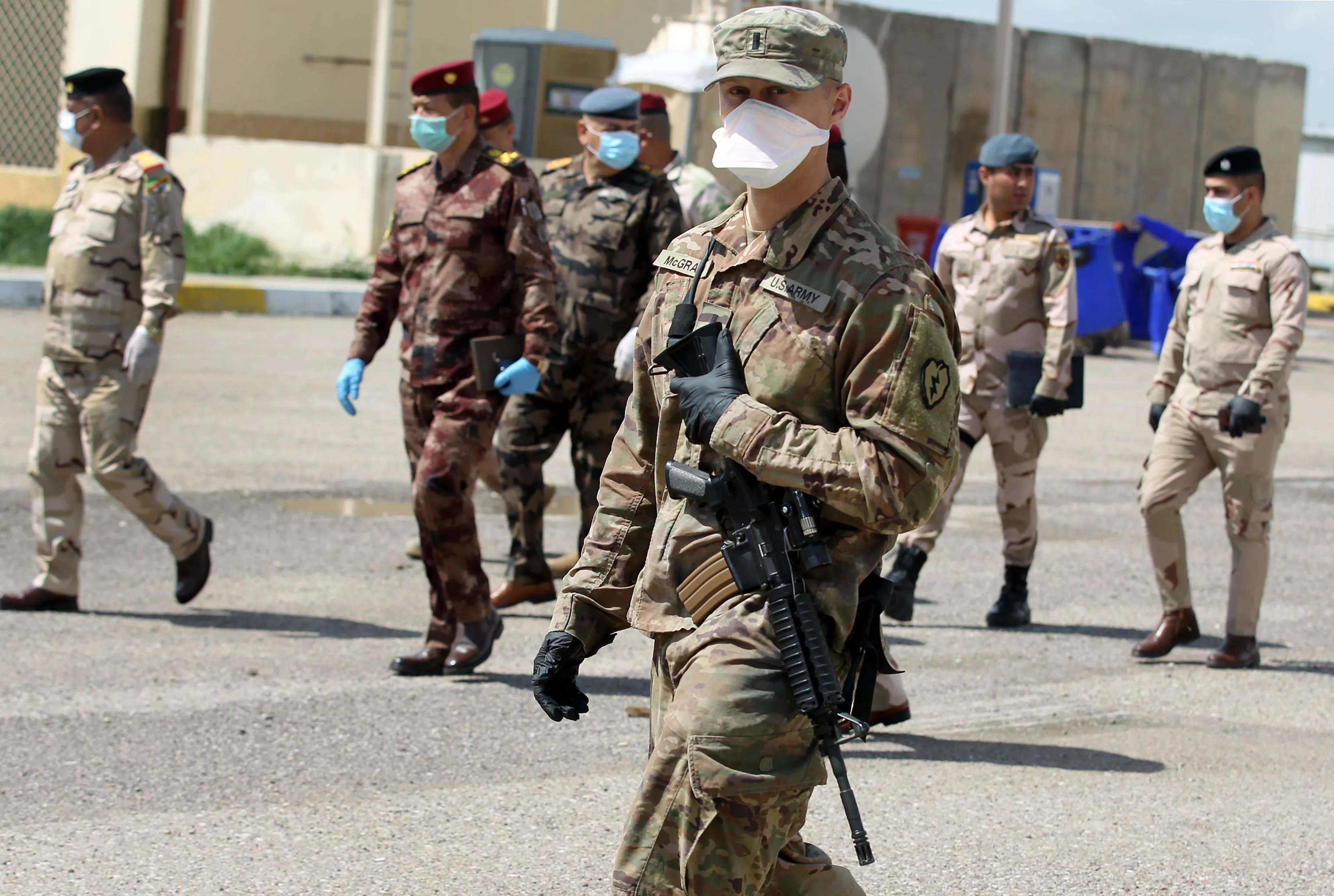 Iraqi soldiers and a US army soldier, part of the Combined Joint Task Force Operation Inherent Resolve (CJTF-OIR) the US-led coalition against the Islamic State (IS) group, walk around at the K1 Air Base northwest of Kirkuk in northern Iraq&nbsp;on March 29.