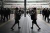 A woman walks outside a train station in Tokyo's business district, Japan.