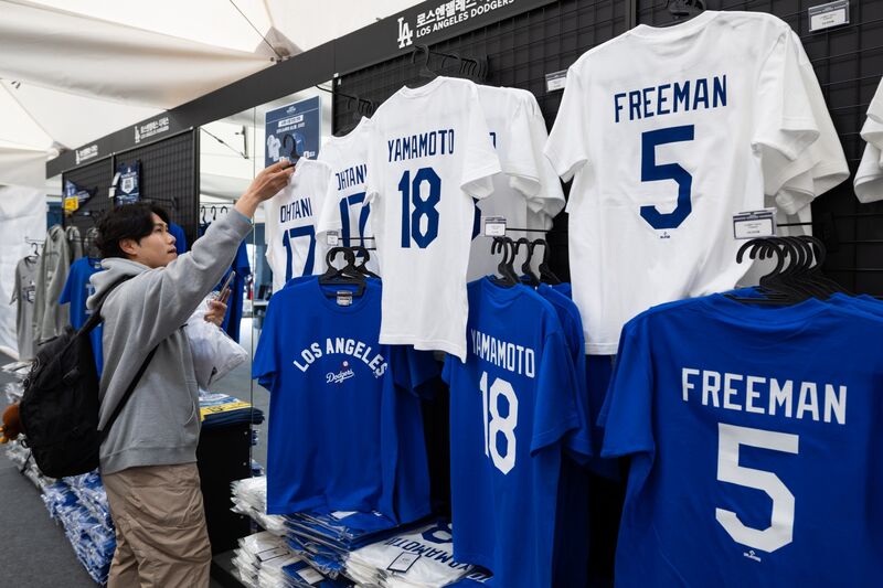 A fan looks at T-shirts of Shohei Ohtani, baseball player of the Los Angeles Dodgers.